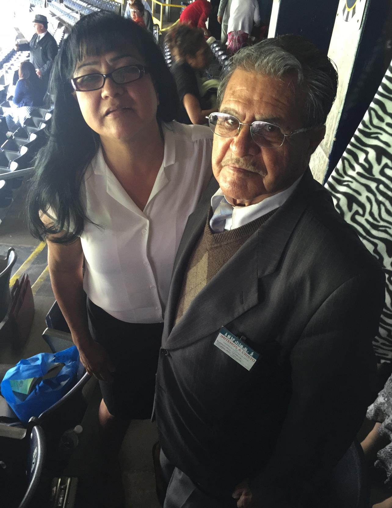 Two people stand closely in the stadium, capturing a moment during a lively event.