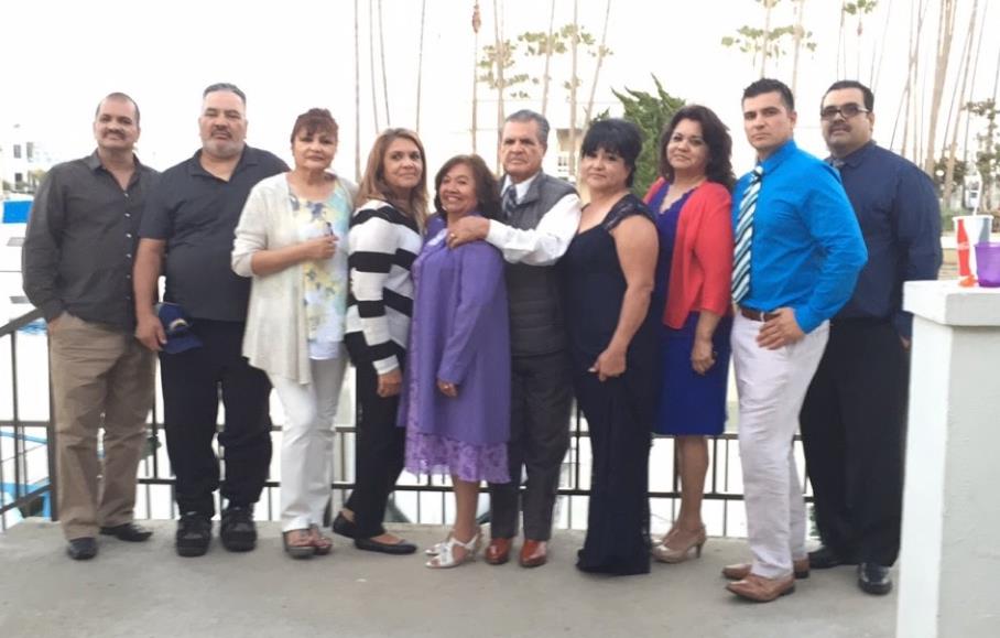 A joyful gathering of family members poses together at a marina, celebrating a special moment.
