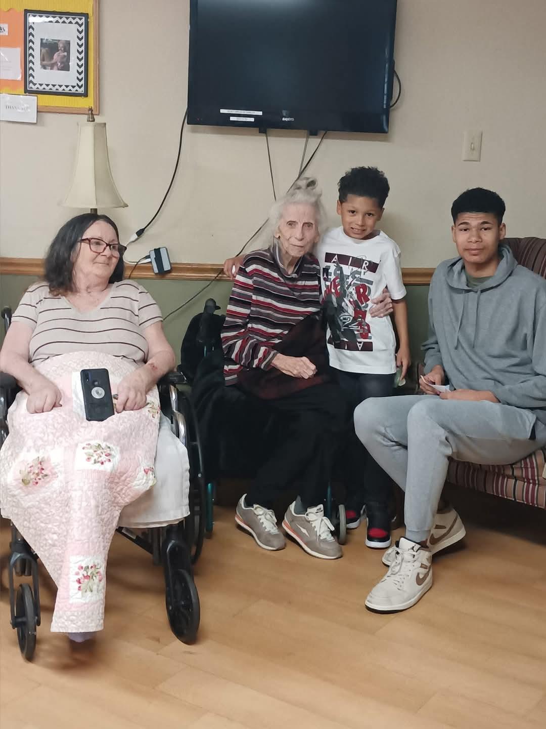 Multiple generations gather in a care home, sharing smiles and warm moments of connection.
