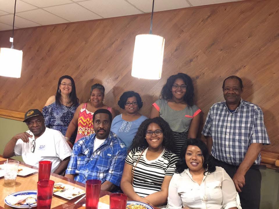 Group of family members seated at a table in a restaurant enjoying food and conversation.