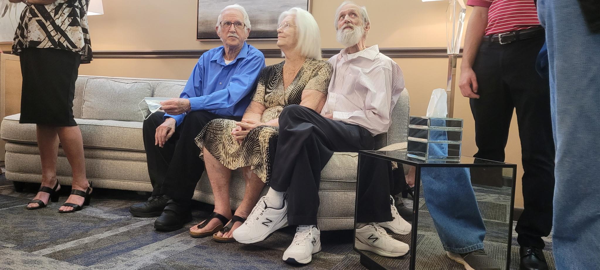 Couple and friend relax and share laughs at a welcoming community event.