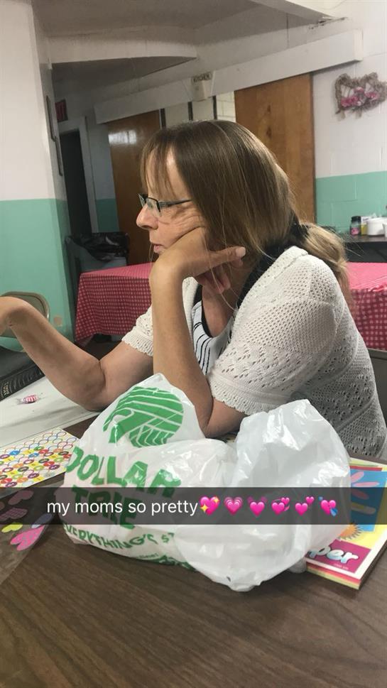 A woman sitting at a table with her hand on her face
