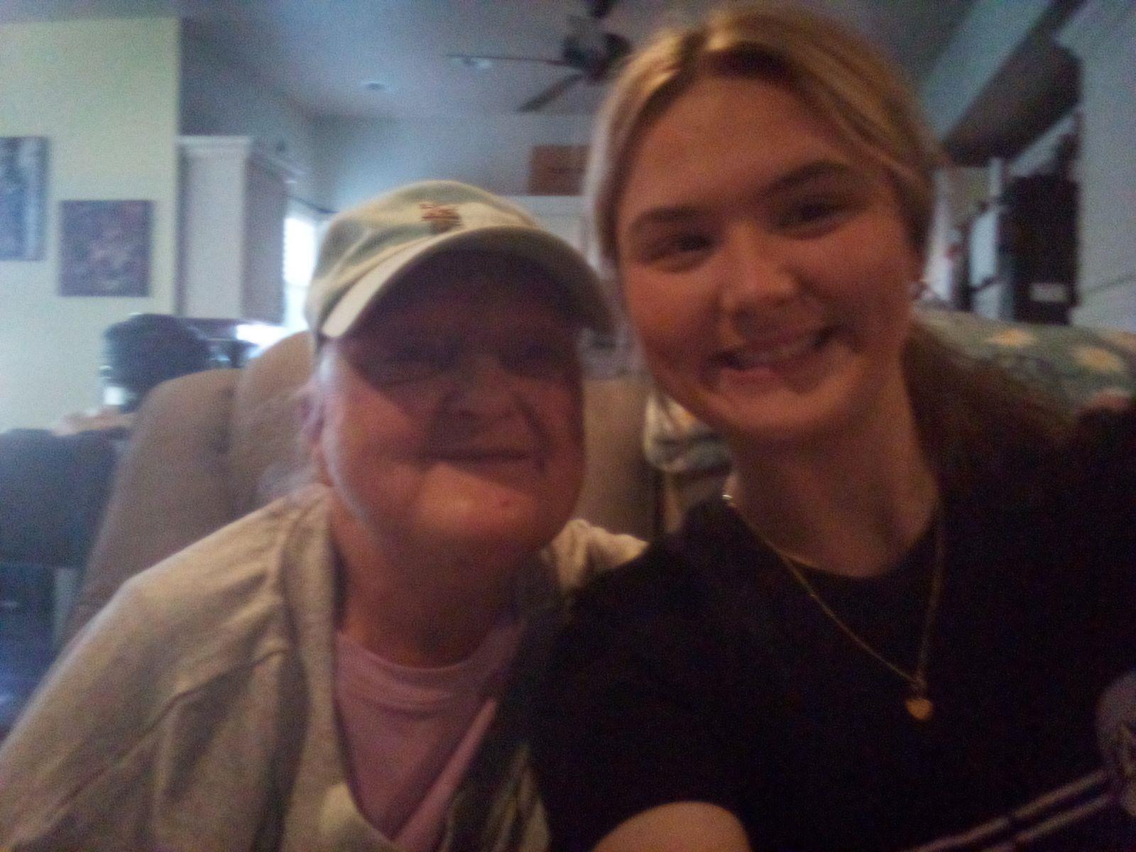 Two women smile together in a welcoming living room, capturing a warm, shared experience.