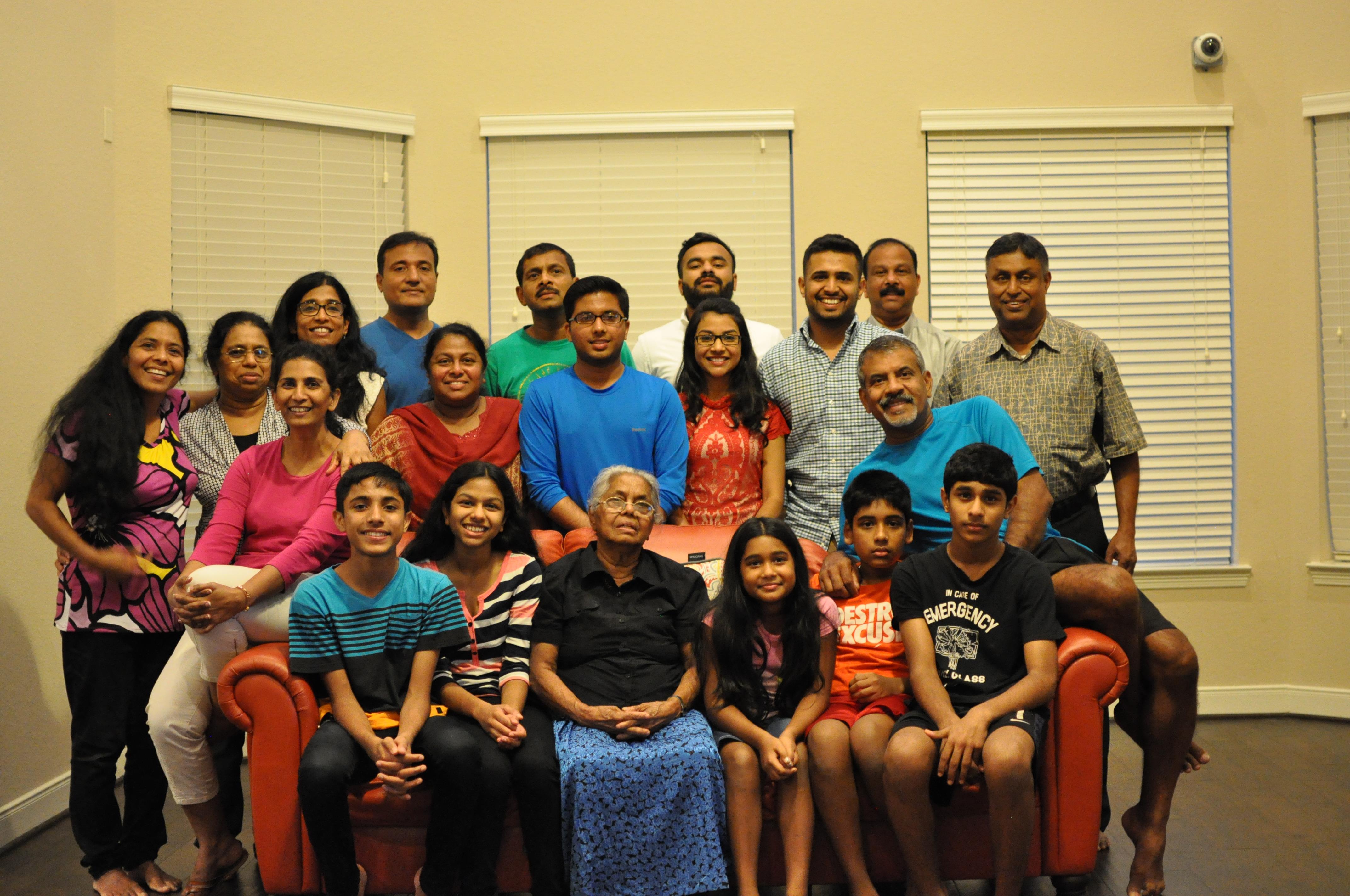 A large family gathers together in a cozy living room, enjoying each other's company.