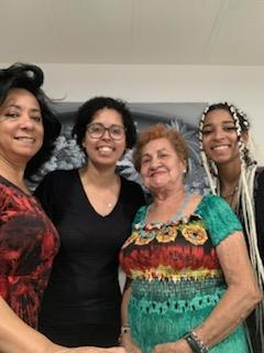 Four women of varied generations unite, showcasing family ties and cultural pride.