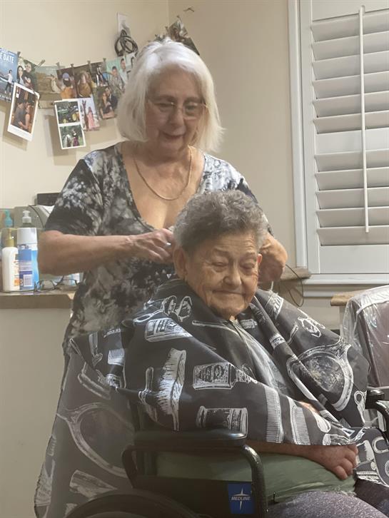 A woman cutting an older woman's hair
