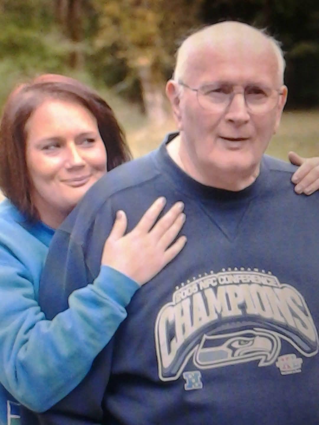 A young woman joyfully hugs an elderly man, highlighting their close bond.