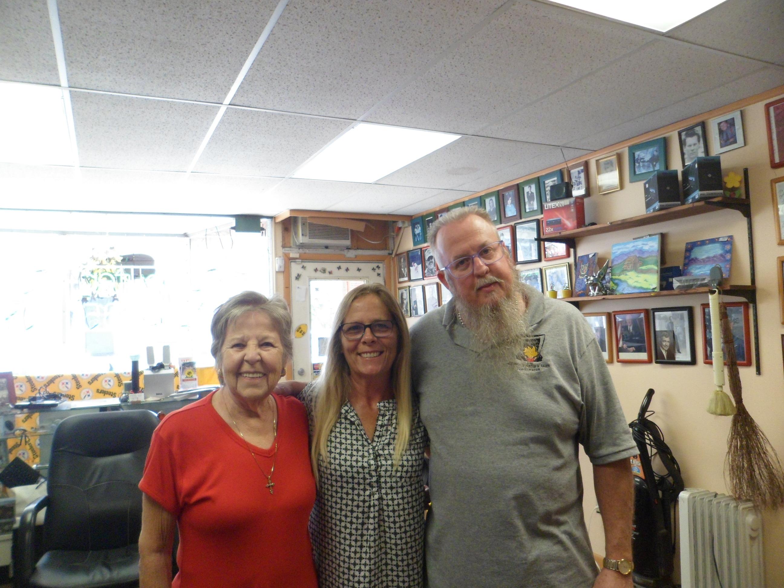 Three friends smile together in a welcoming space filled with memories and warmth.