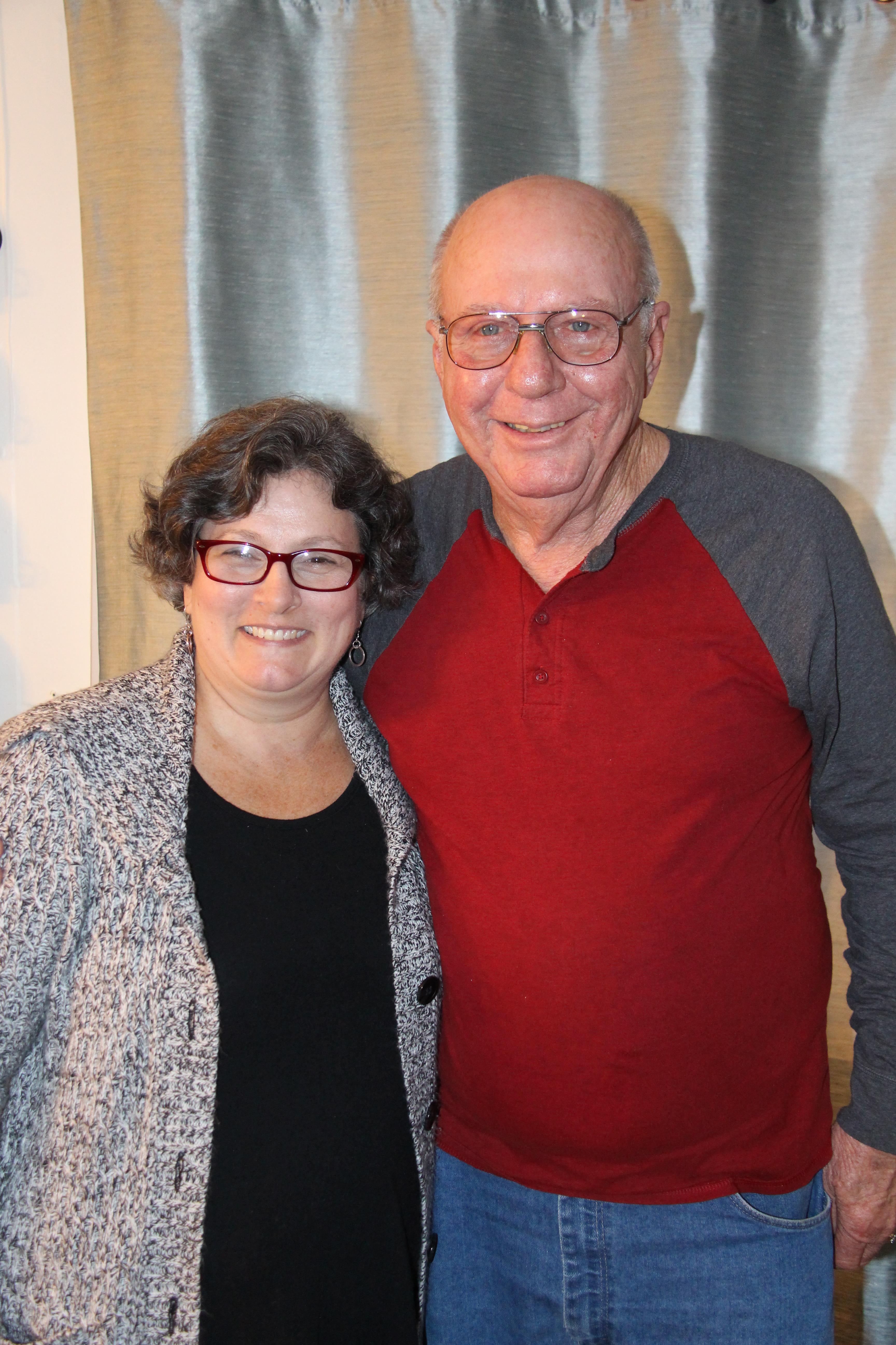 A warm reunion where two family members smile happily in a relaxed indoor environment.