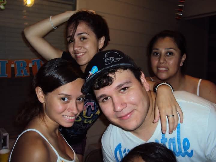 Four friends enjoy a joyful moment together at a birthday celebration, smiling and posing.