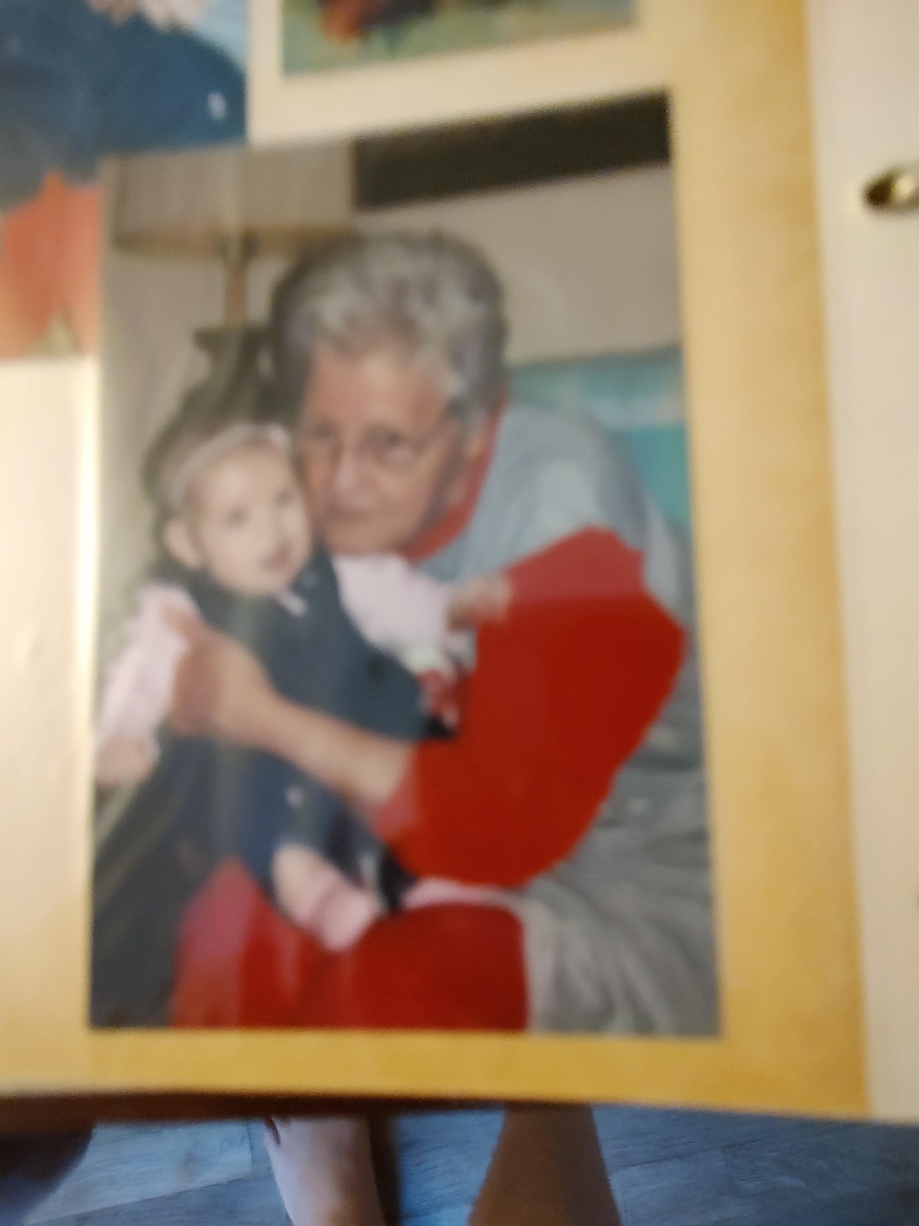 An elderly woman holds a baby lovingly during a family gathering in a warm and inviting space.