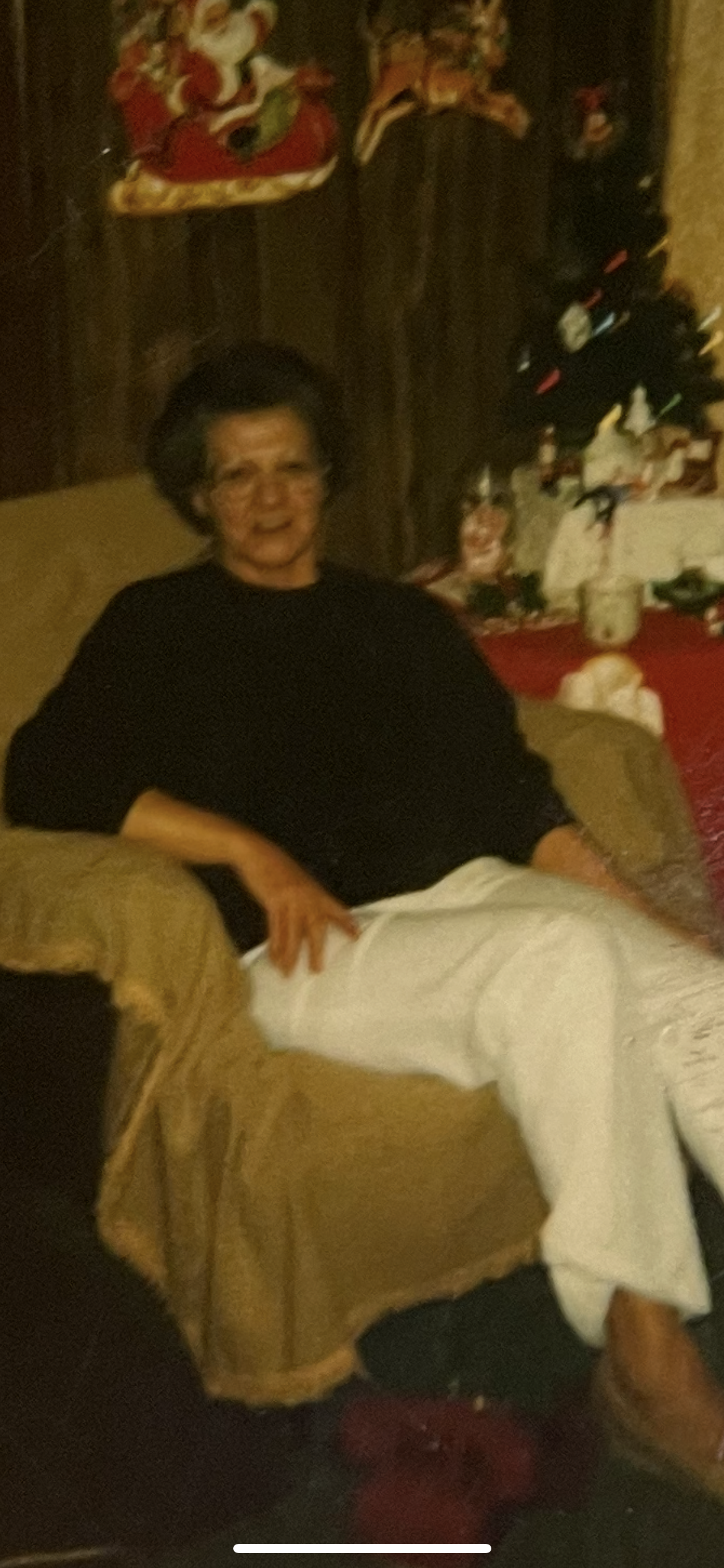 An elderly woman relaxes in a cozy chair, surrounded by holiday decorations and festive atmosphere.