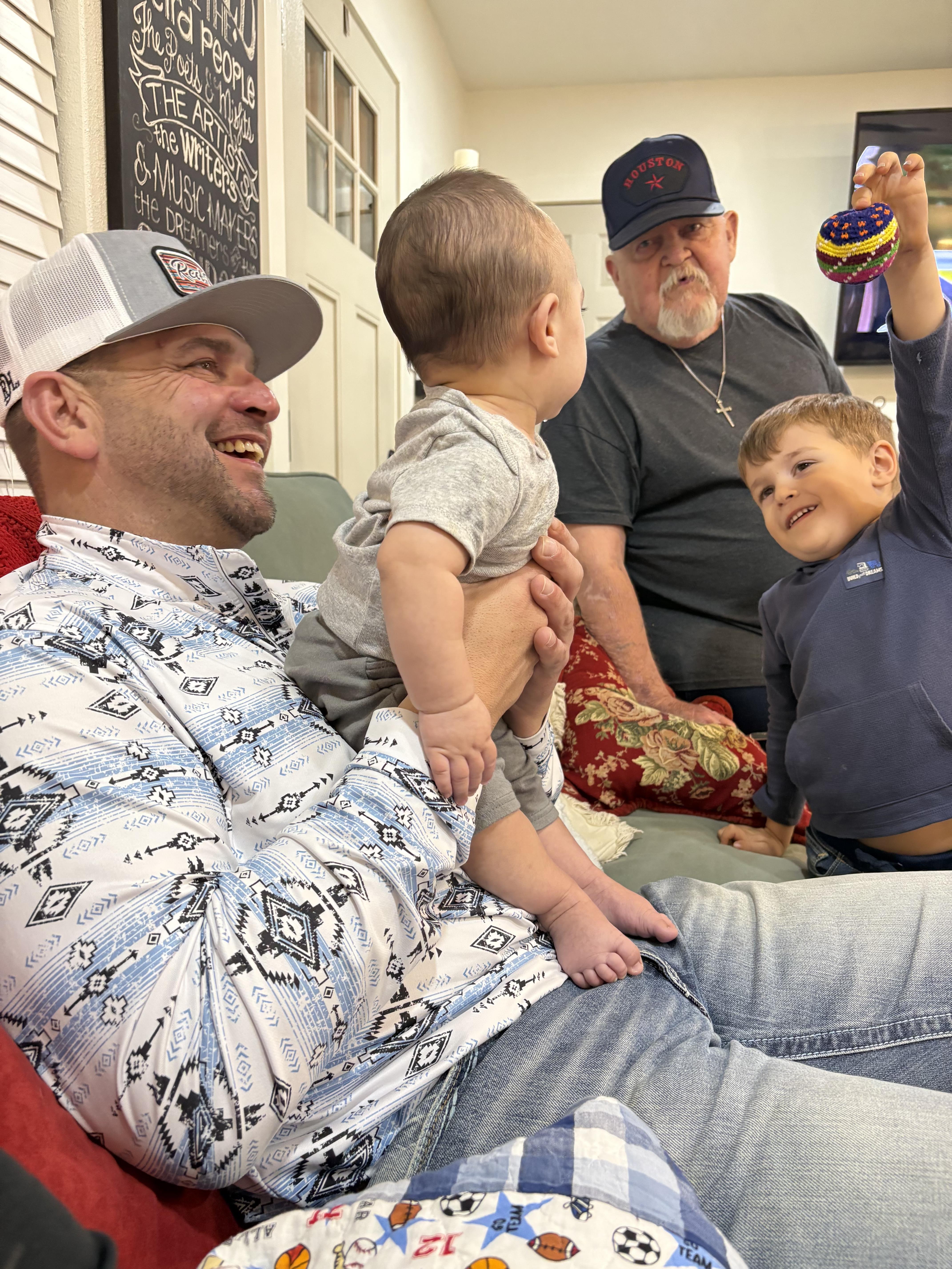 Family members gather in a warm living room, sharing smiles and bonding with playful kids.
