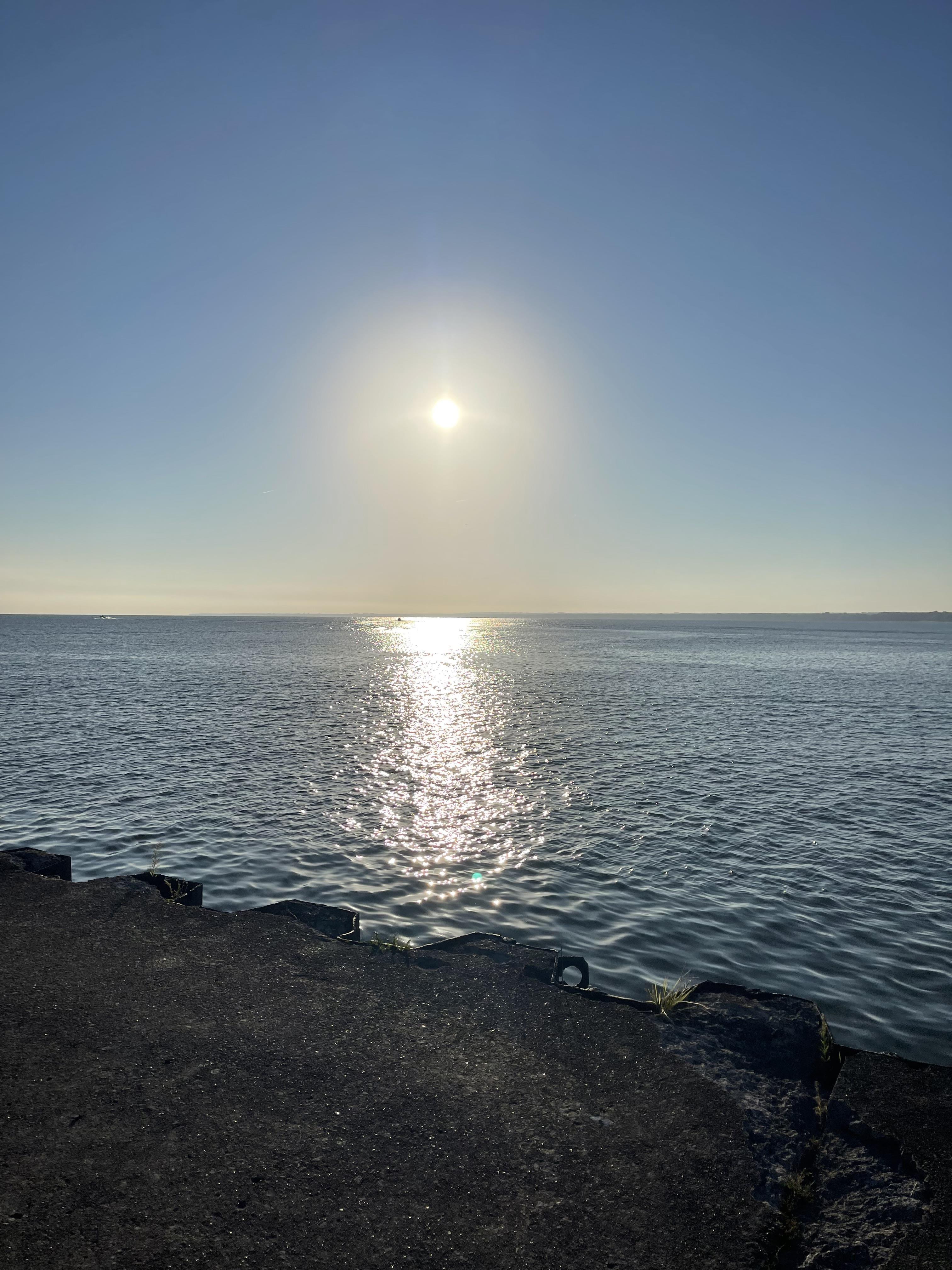 Sunlight glimmers on the calm lake surface, creating a peaceful morning ambiance.