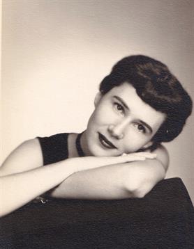 A woman with an elegant hairstyle relaxes with her arms crossed, exuding nostalgia and charm.