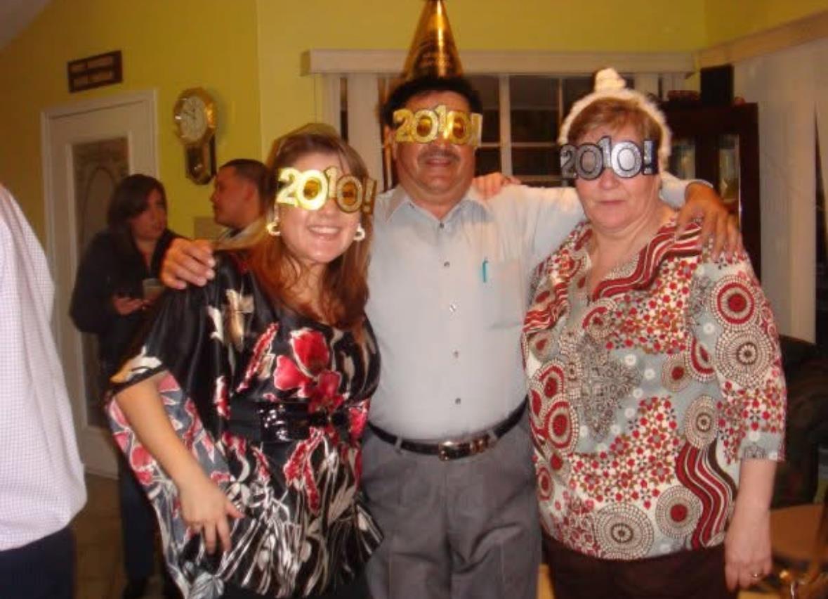 Friends gather to celebrate New Year 2010 wearing festive hats and unique glasses indoors.
