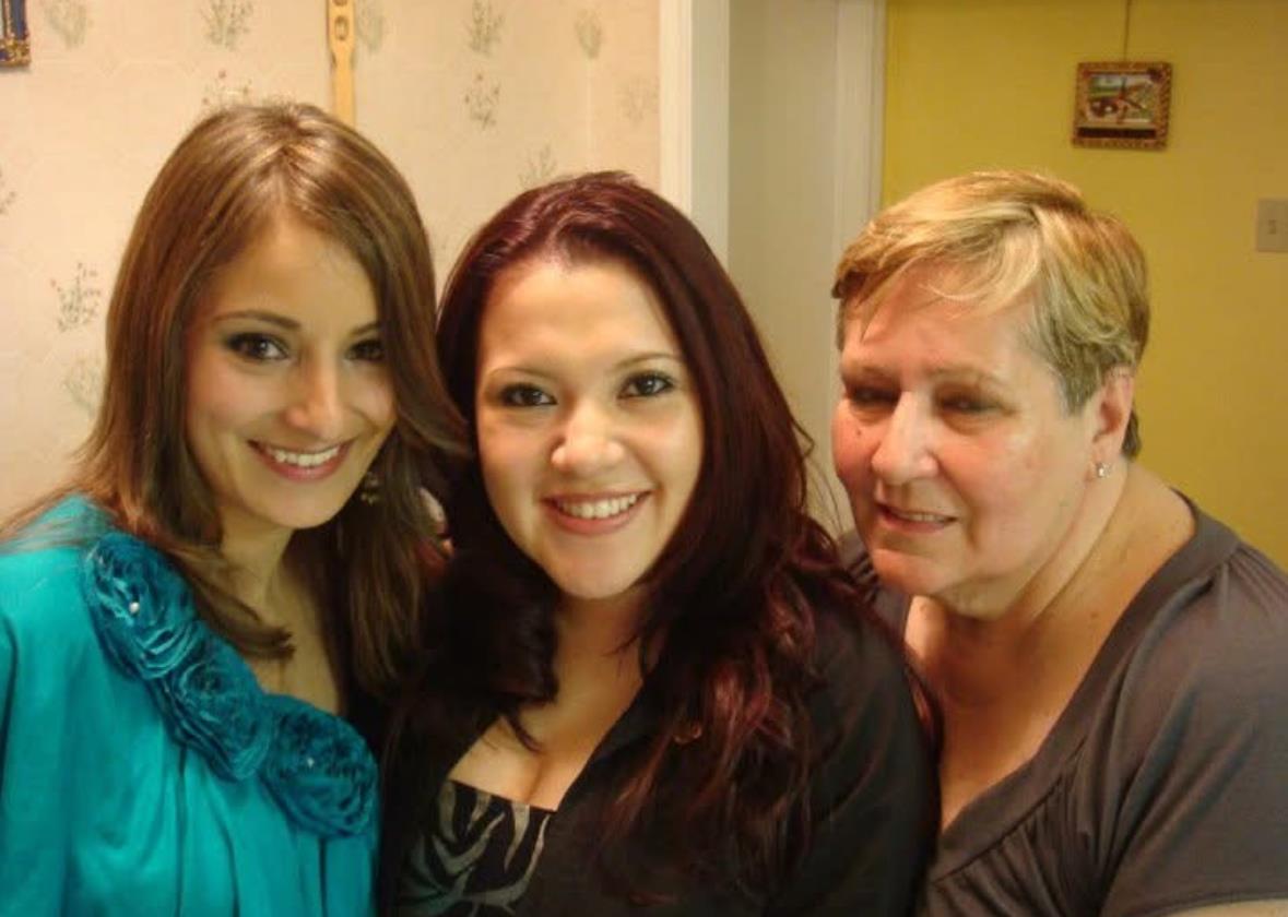 Smiling women pose together in a cozy indoor setting filled with warmth and happiness.