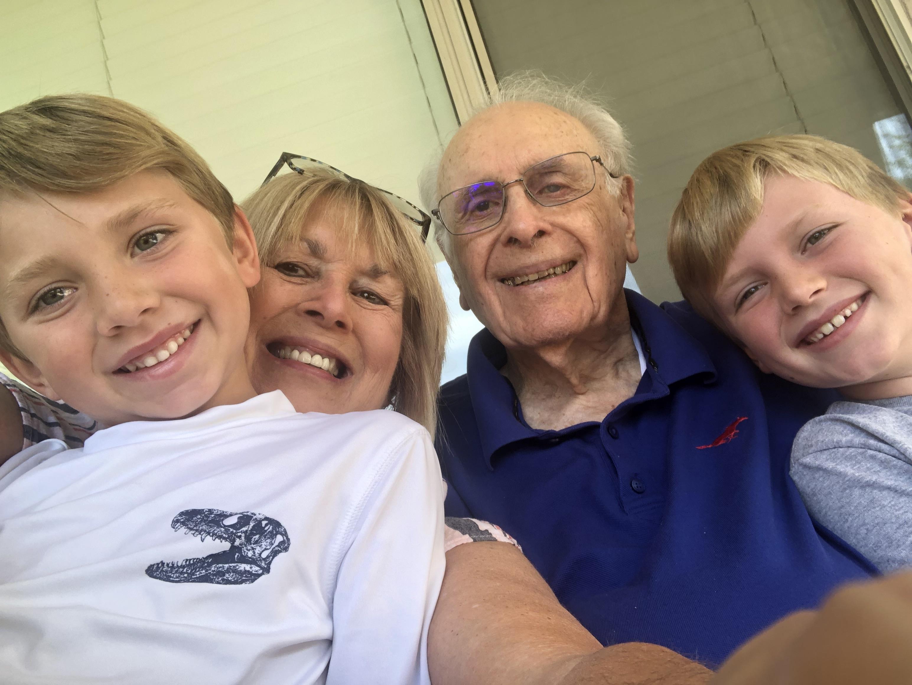 Smiling family members enjoy a warm afternoon together, capturing a joyful moment on a porch.
