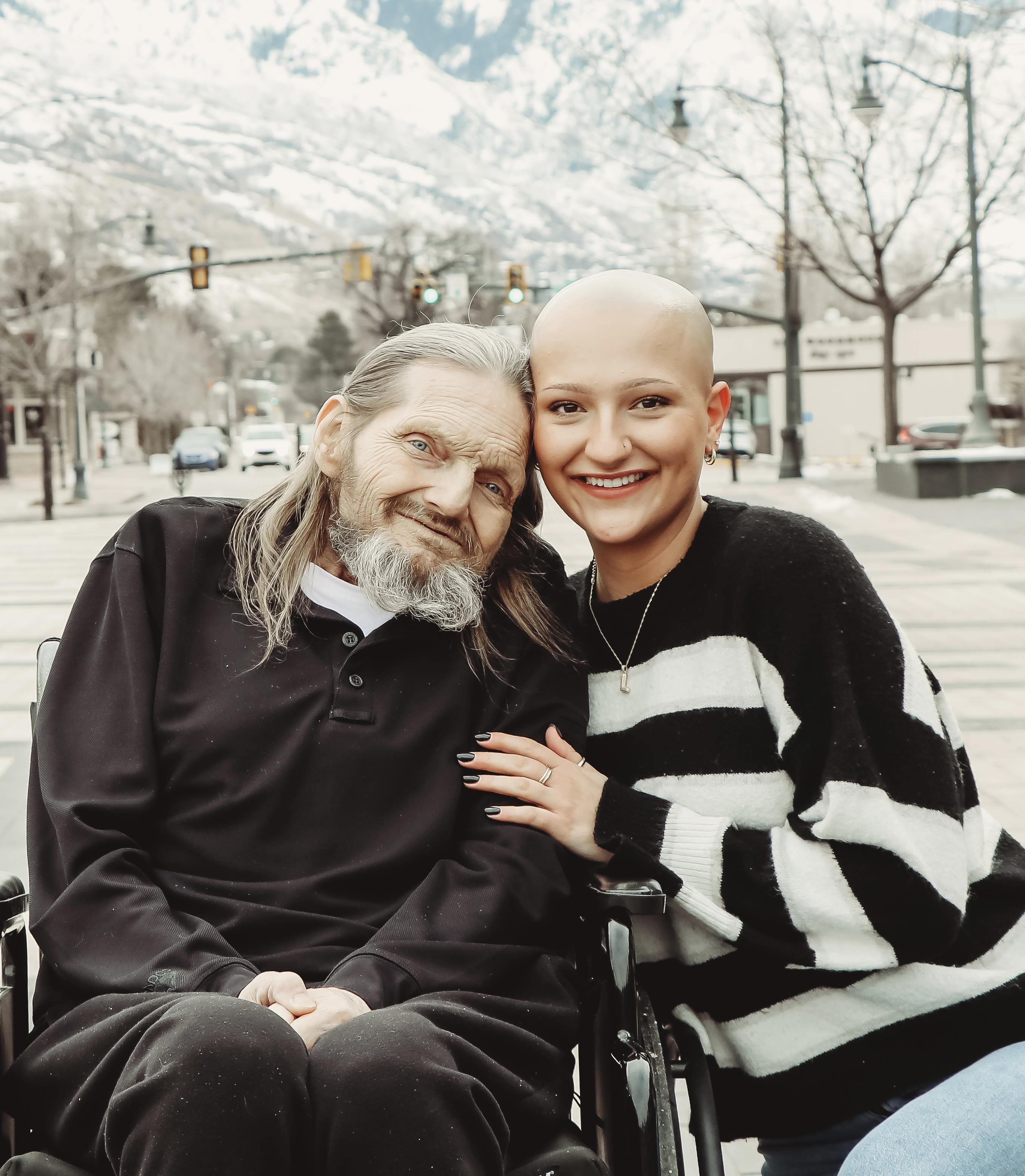 A woman sitting on a wheelchair with a man in a wheelchair