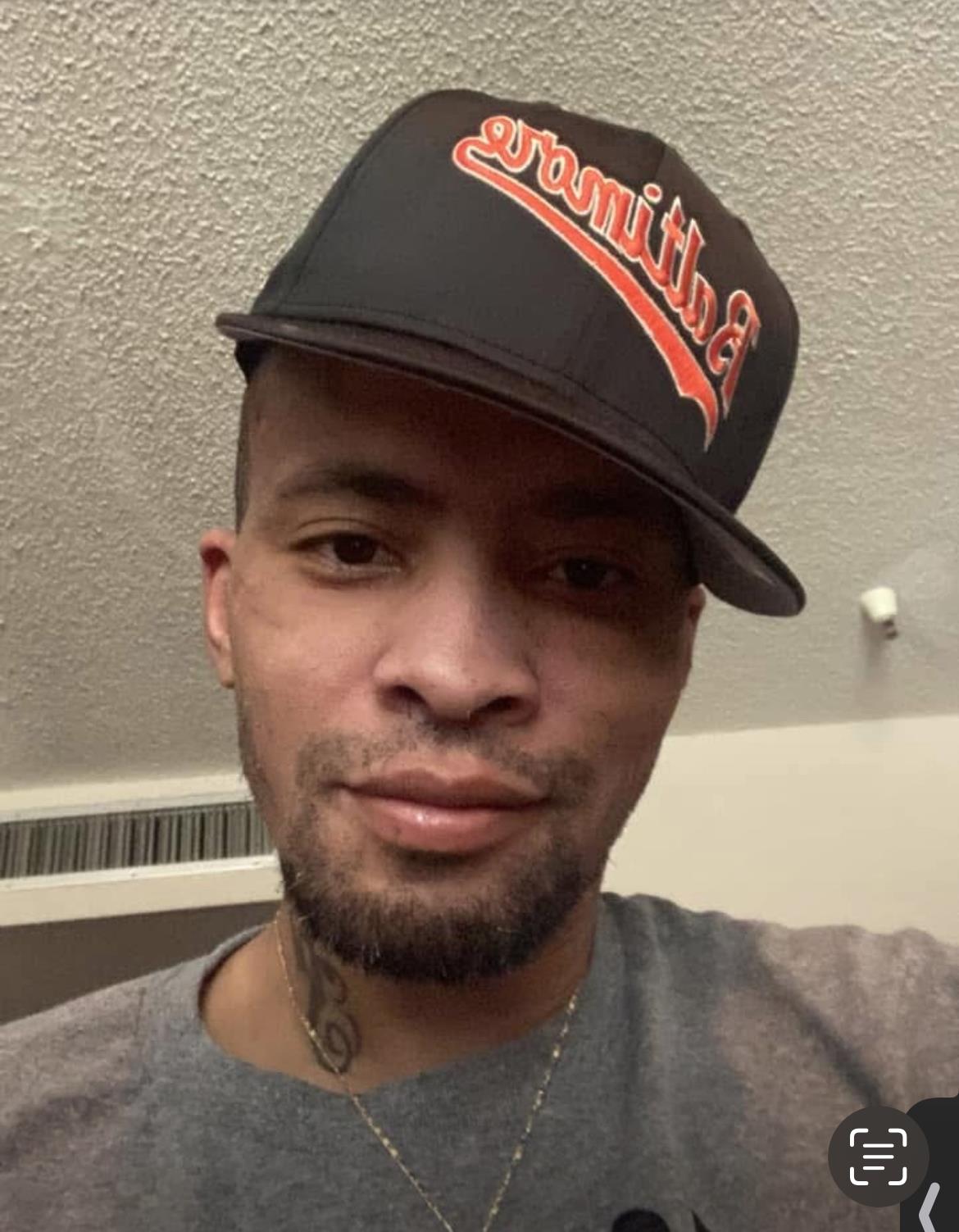 Individual with a distinctive hat takes a selfie, showcasing a relaxed indoor atmosphere.