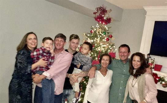 A group of people posing for a photo with a christmas tree