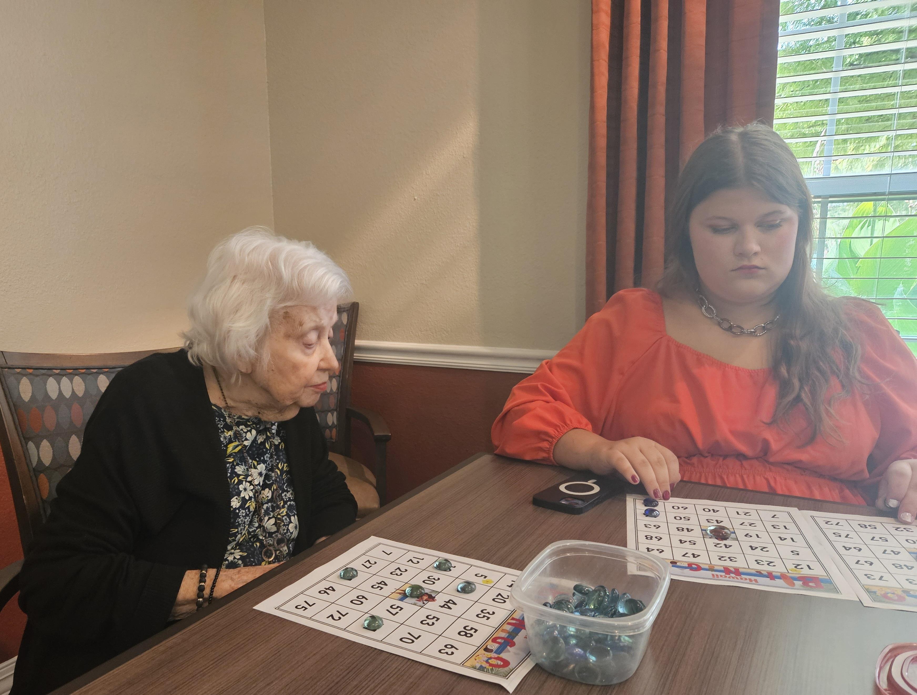Two participants concentrate intently on their bingo cards during a lively game.
