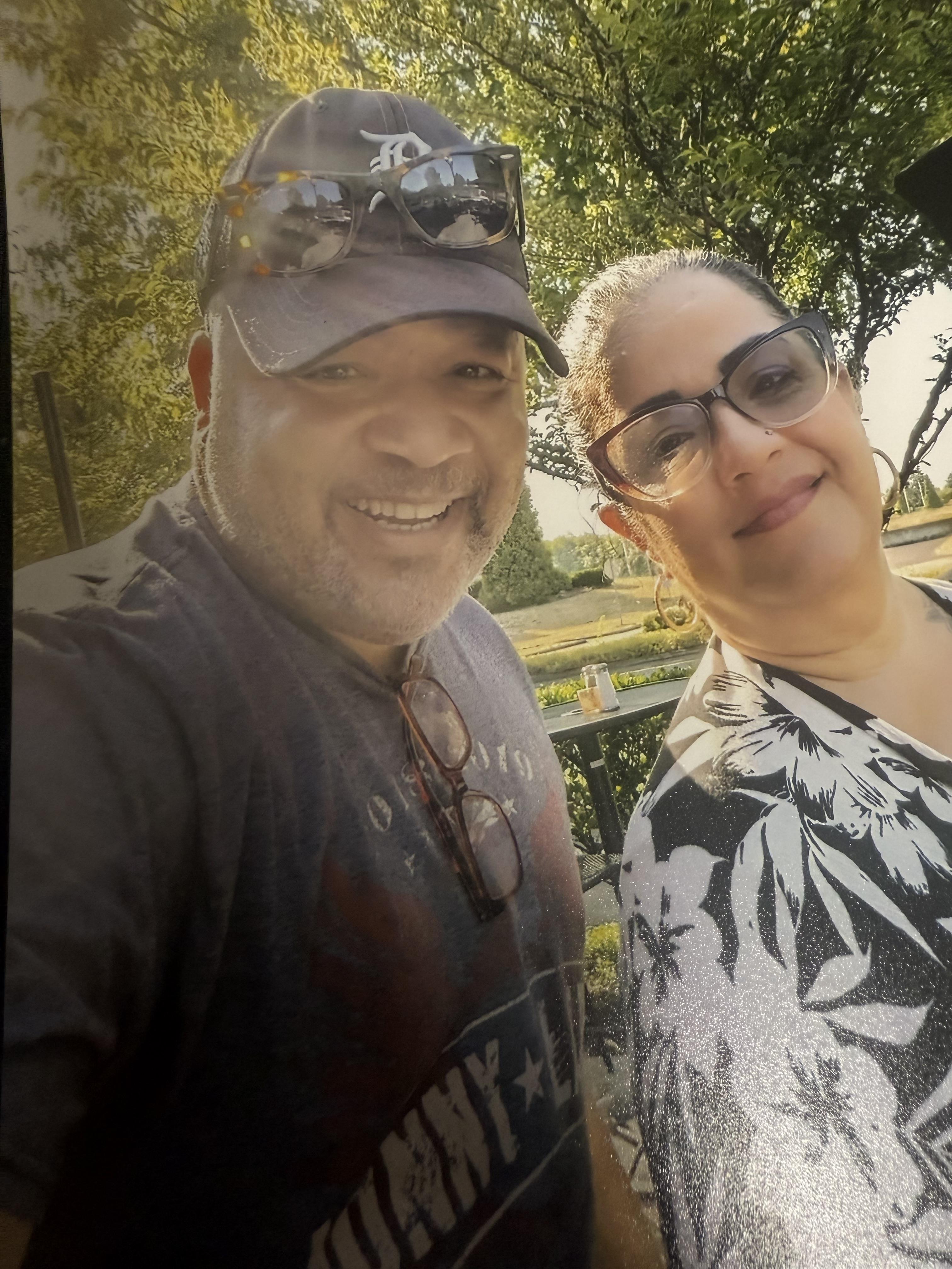 Two friends share smiles while enjoying a sunny afternoon in a park setting.