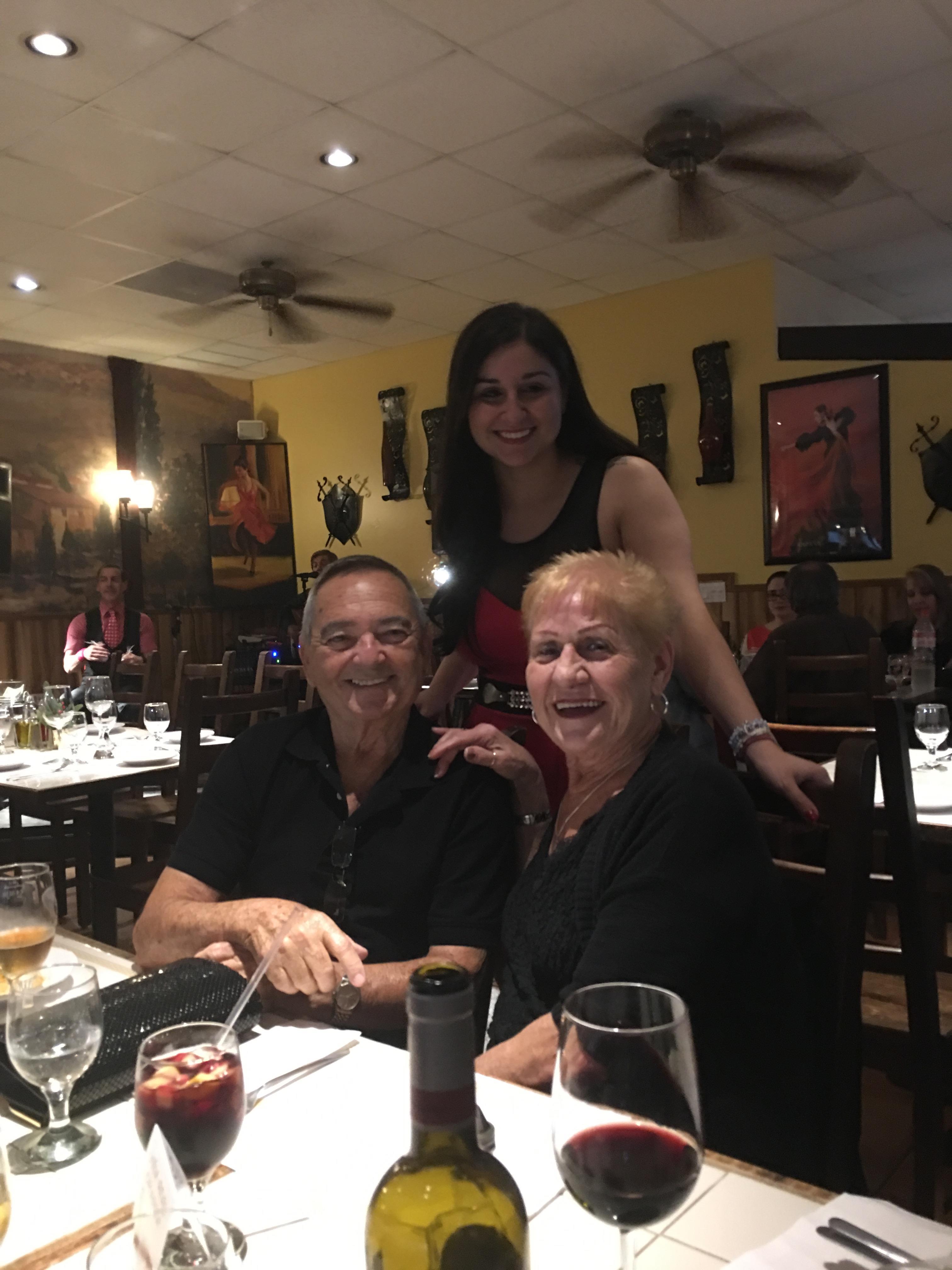 A cheerful group of friends shares laughter and stories over dinner at a restaurant.