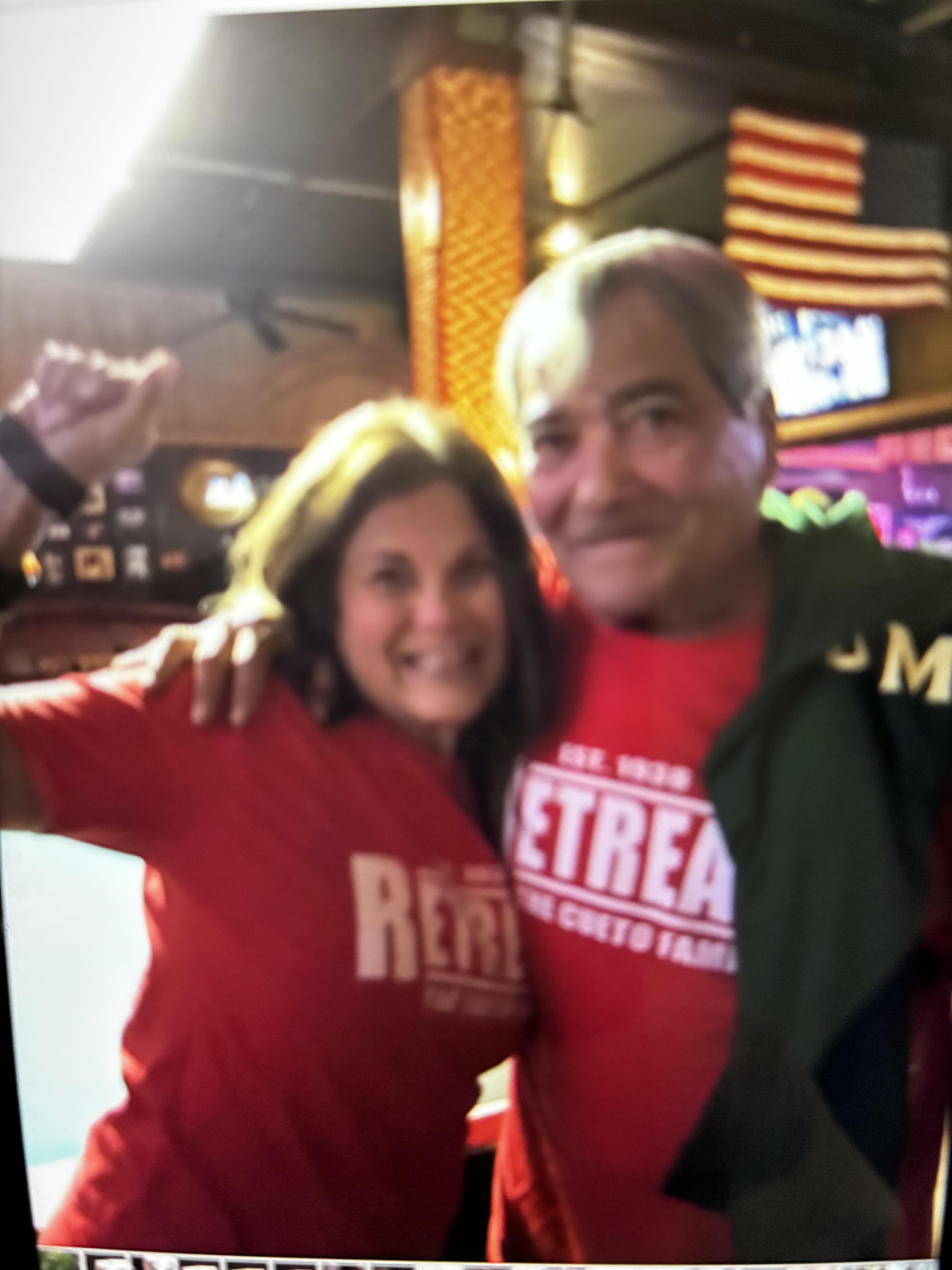Friends celebrate together at a local bar, wearing matching shirts and enjoying the atmosphere.