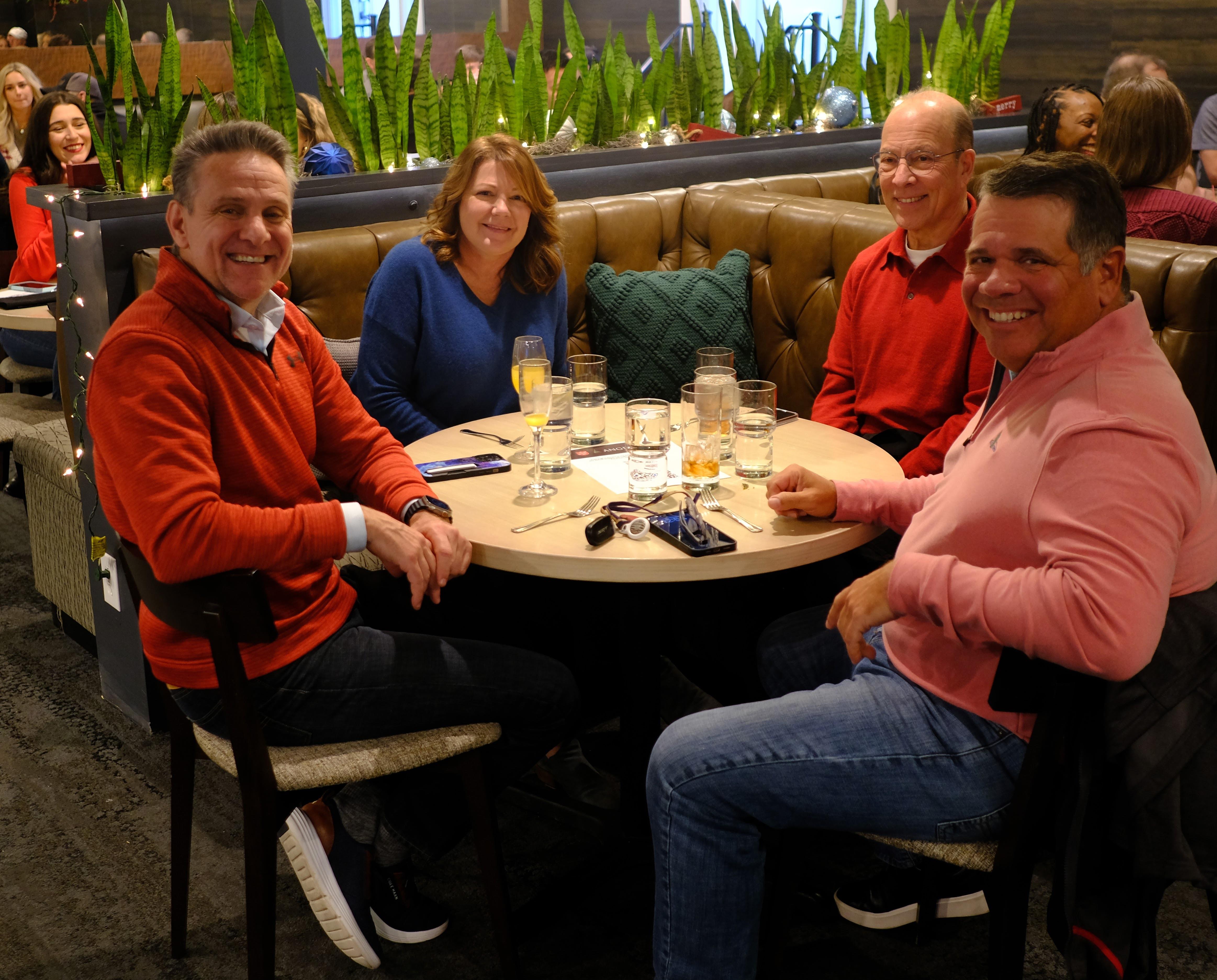 Four friends enjoy dinner and drinks at a cozy restaurant.