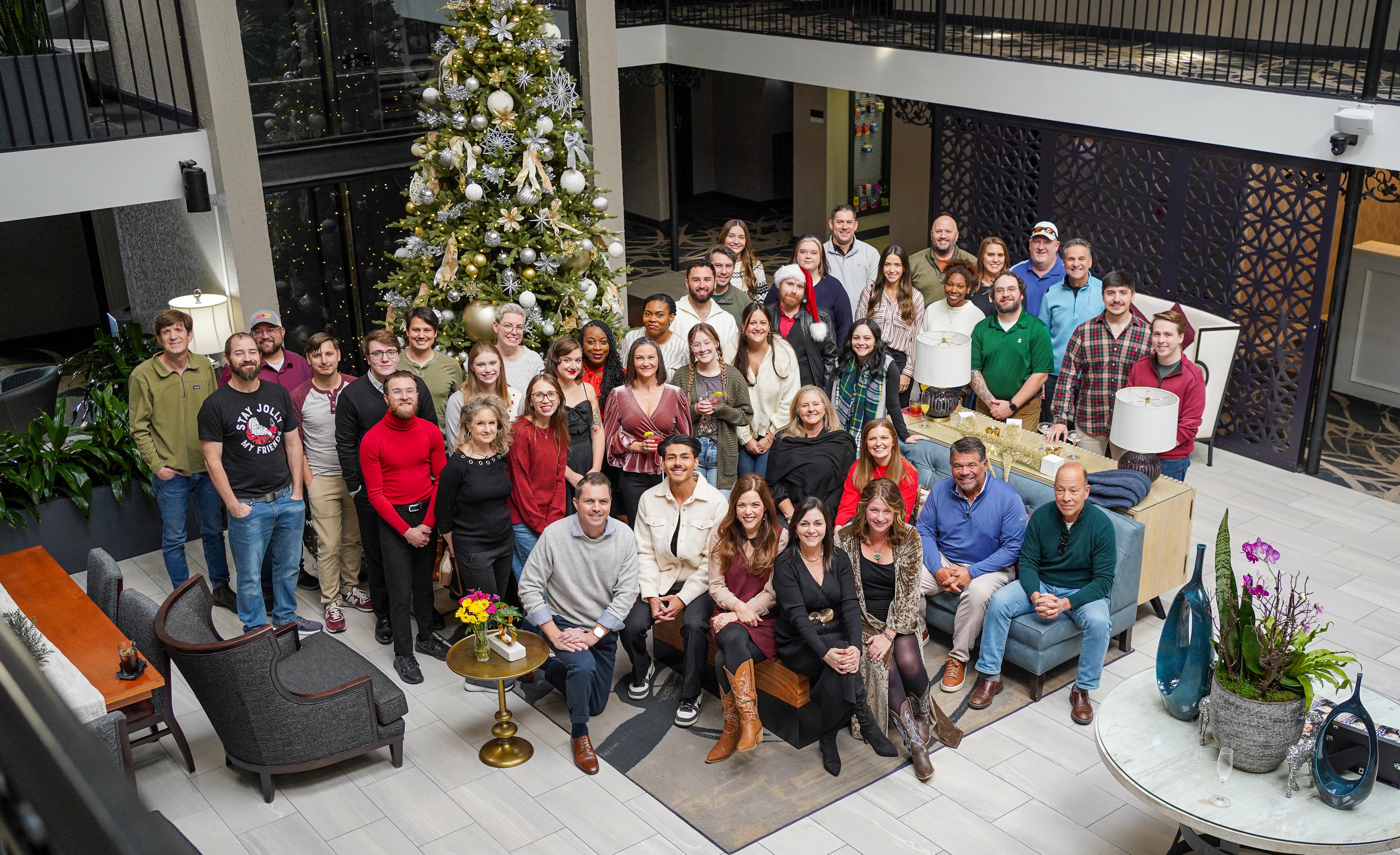 Colleagues celebrate the season in a festive, smile-filled lobby.