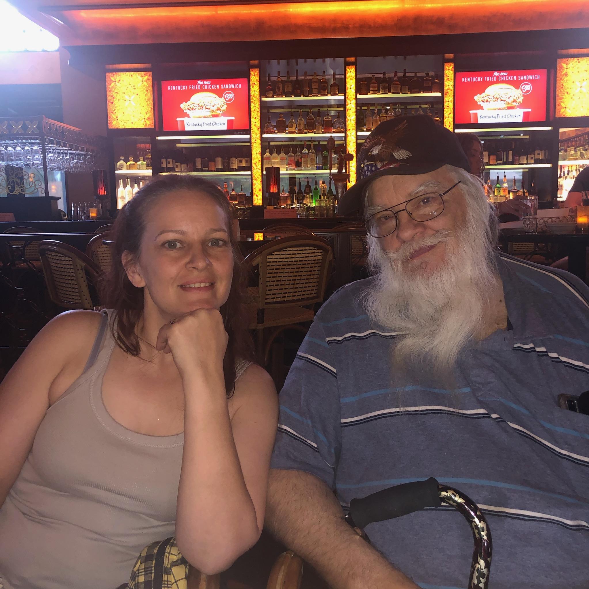 Two friends relax in a lively bar, enjoying each other's company and the vibrant atmosphere.