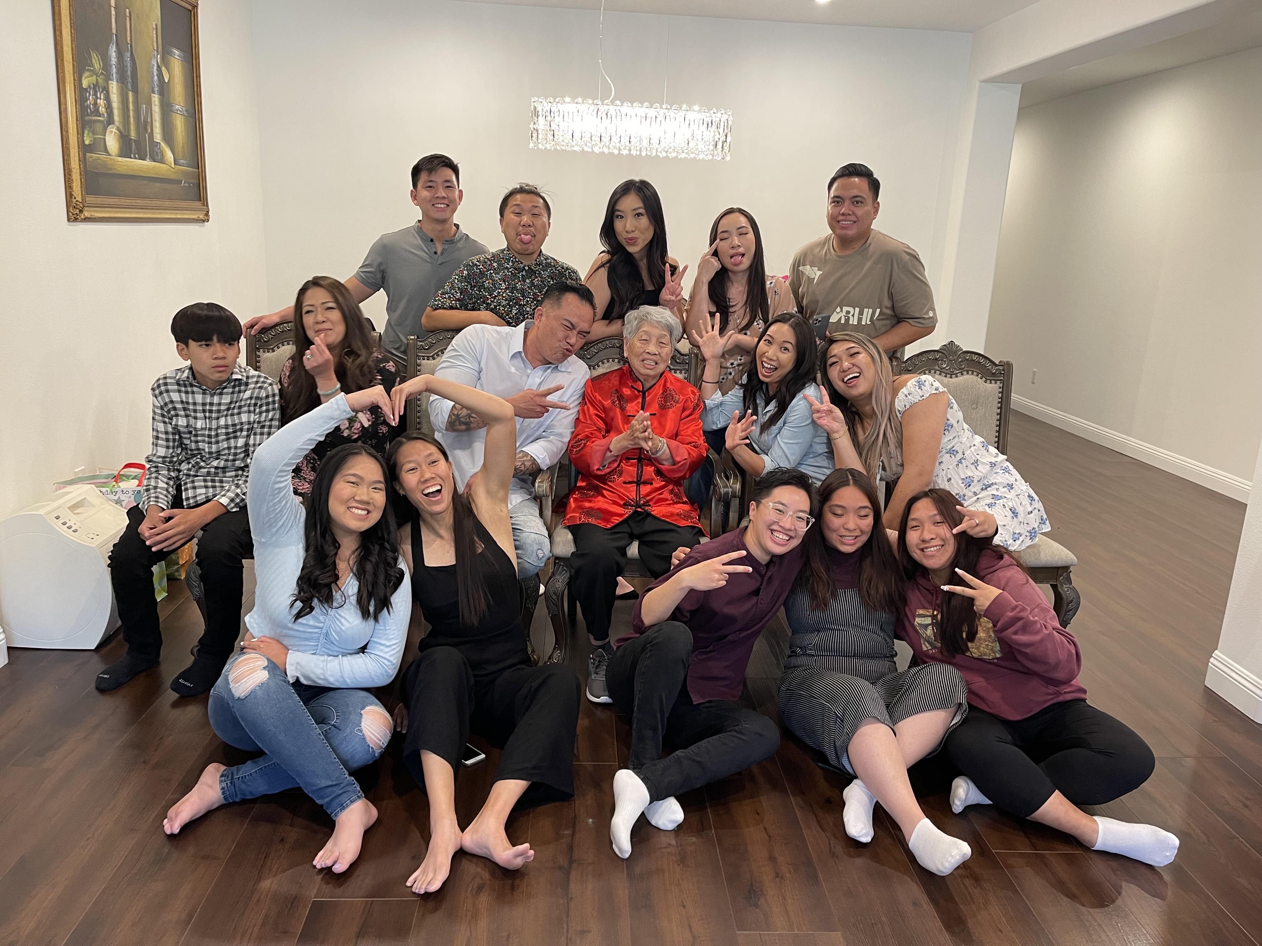 Family members smile and pose in a warm living room during a joyful gathering.