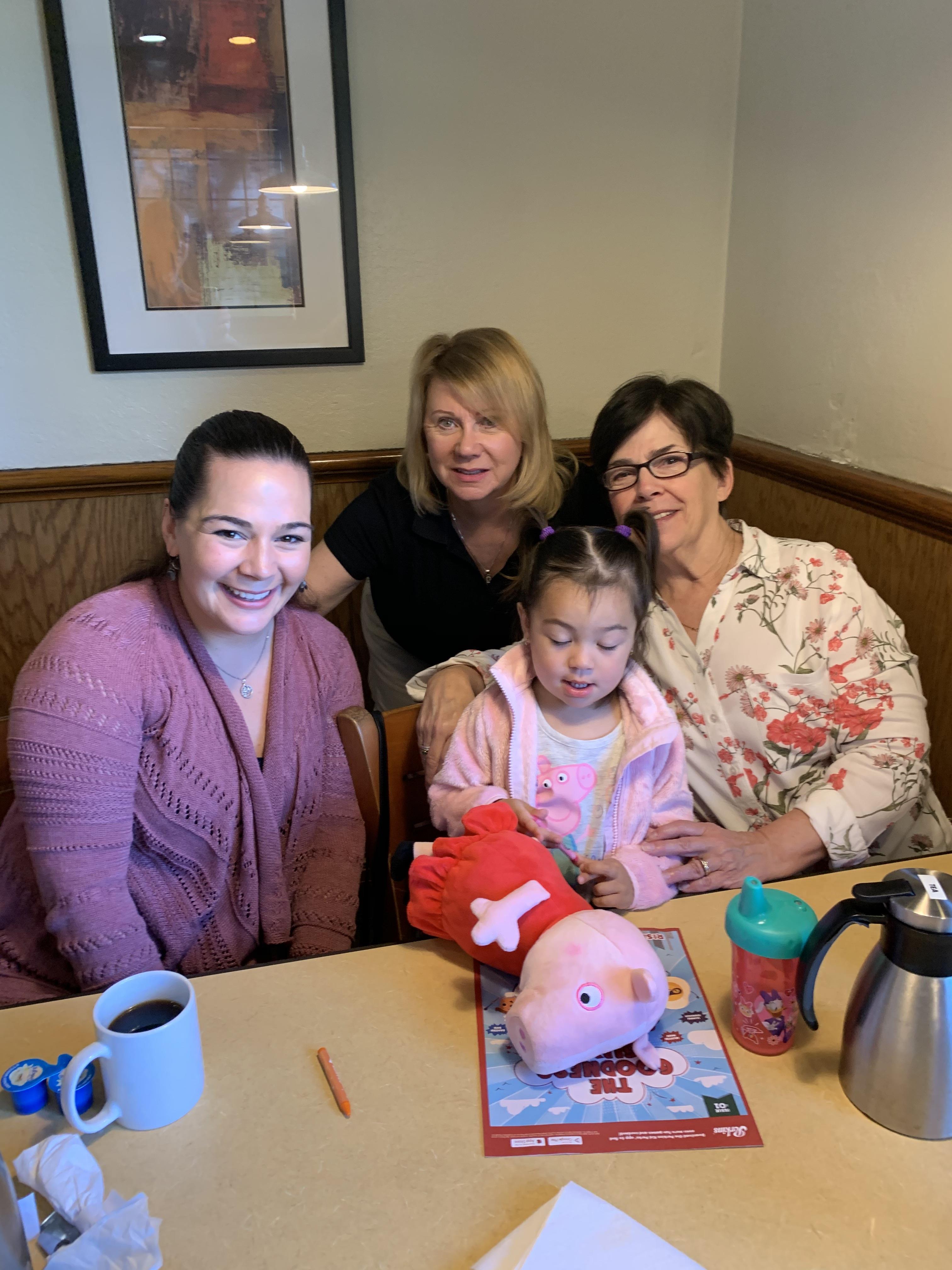 Four family members enjoy a warm moment in a restaurant, sharing smiles and creative activities.