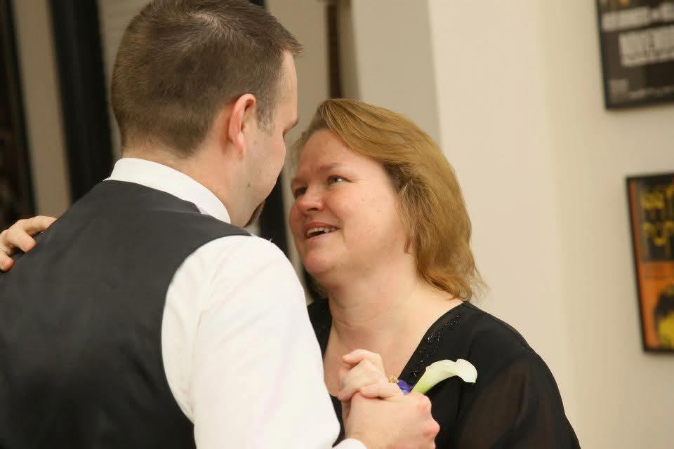An emotional dance takes place between a son and his mother inside a decorated venue at night.