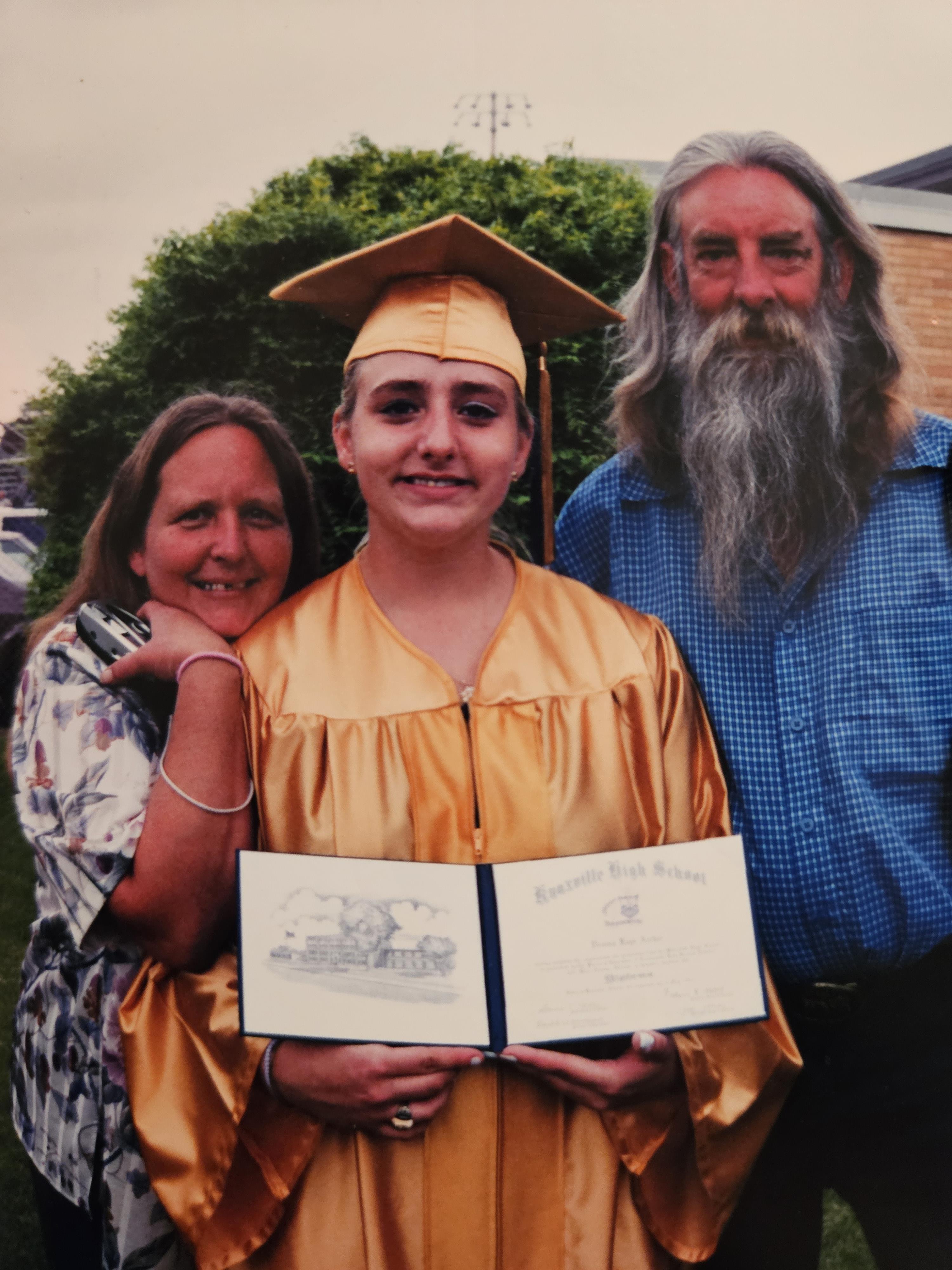 Family gathers to celebrate graduation in a garden, showcasing pride and joy in this special moment.