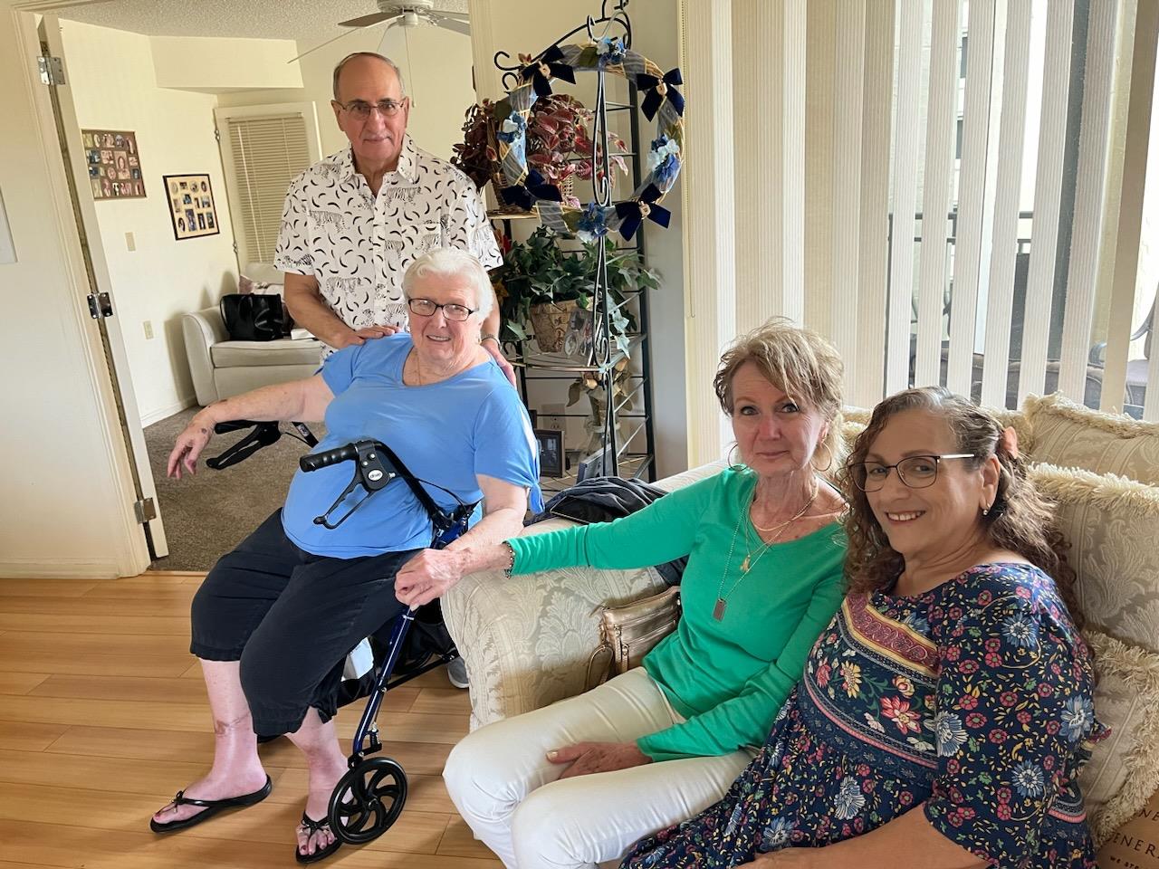 Four friends enjoy each other's company in a bright living room, sharing smiles and stories.