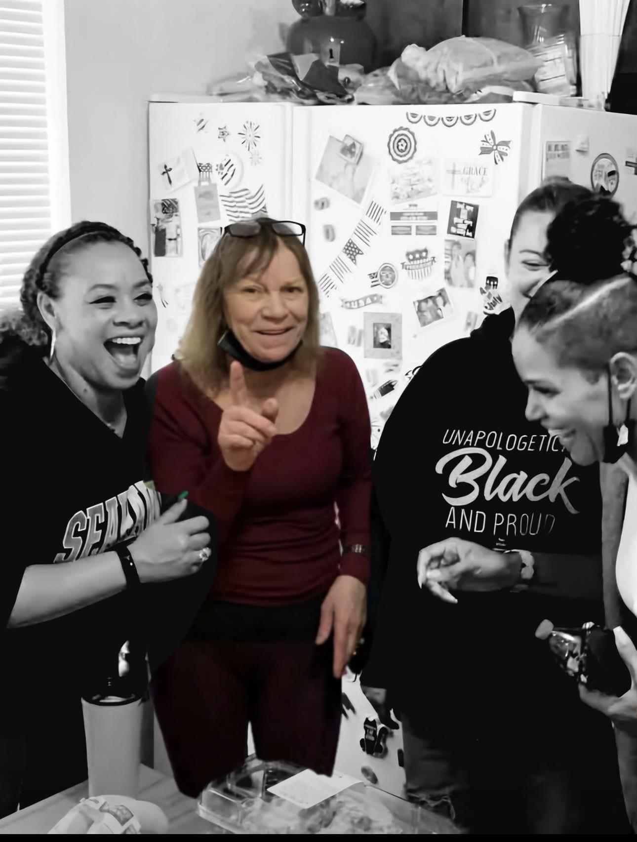 Four friends share laughter and fun in a lively kitchen, enjoying each other's company and snacks.
