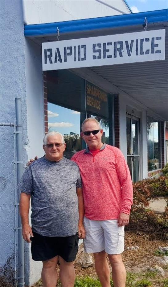 Two men standing in front of a building