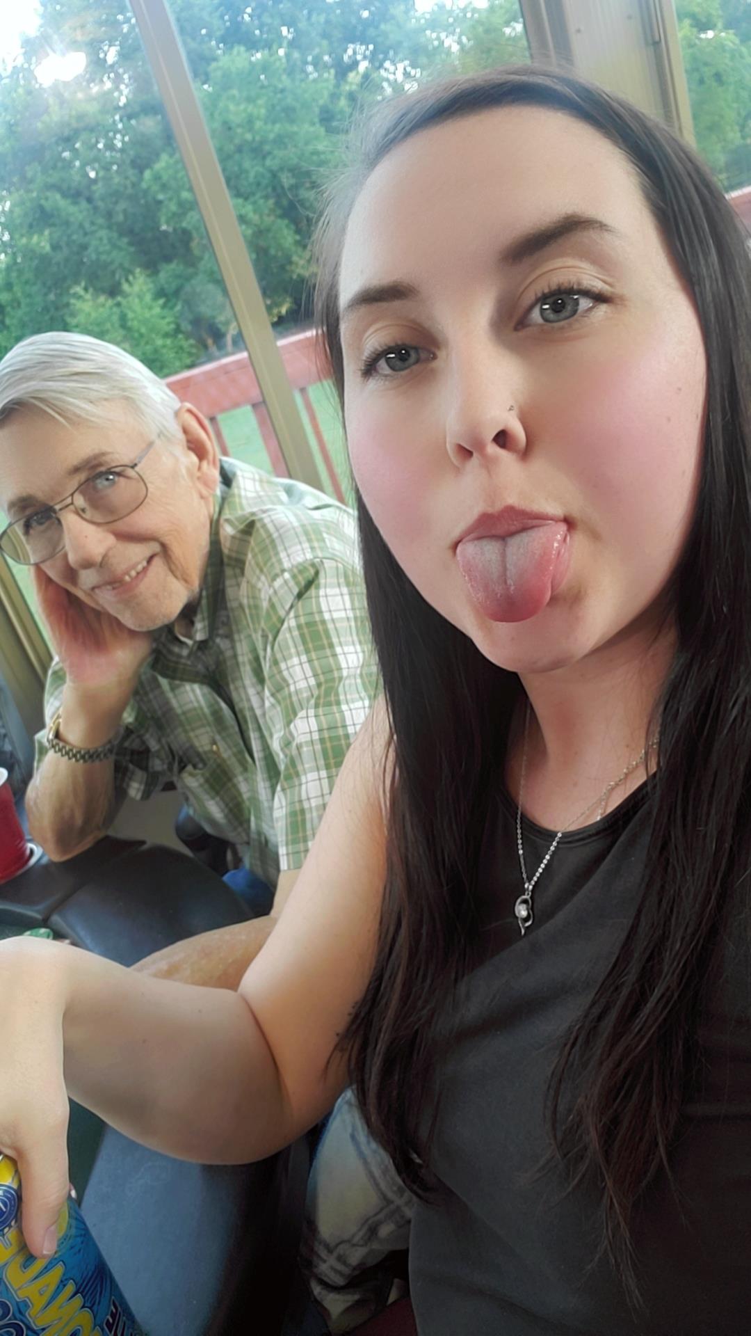 Two people laugh and enjoy a playful moment outdoors in a casual setting.