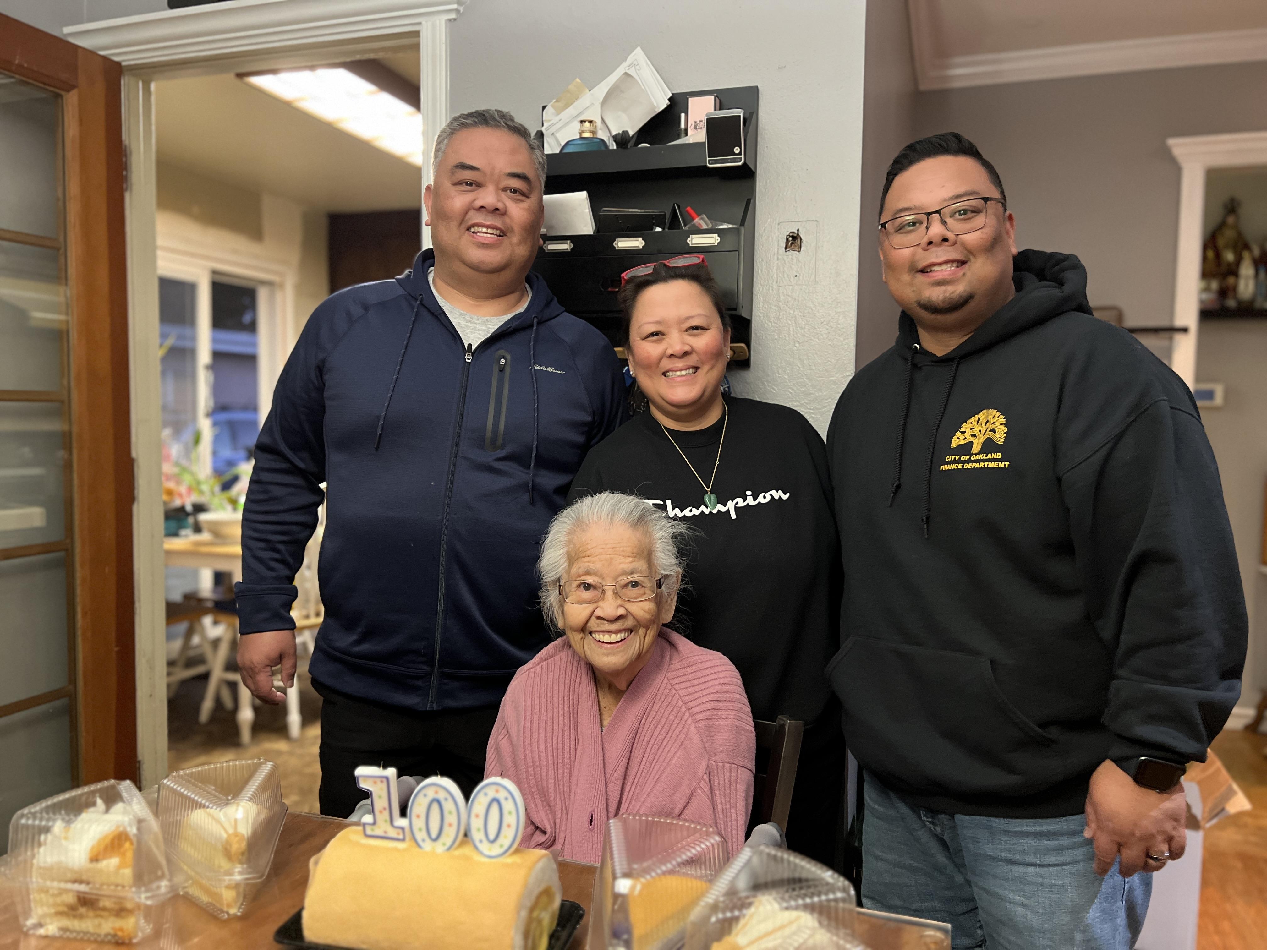 Family celebrates a special occasion with cake, joy, and love in a cozy home.