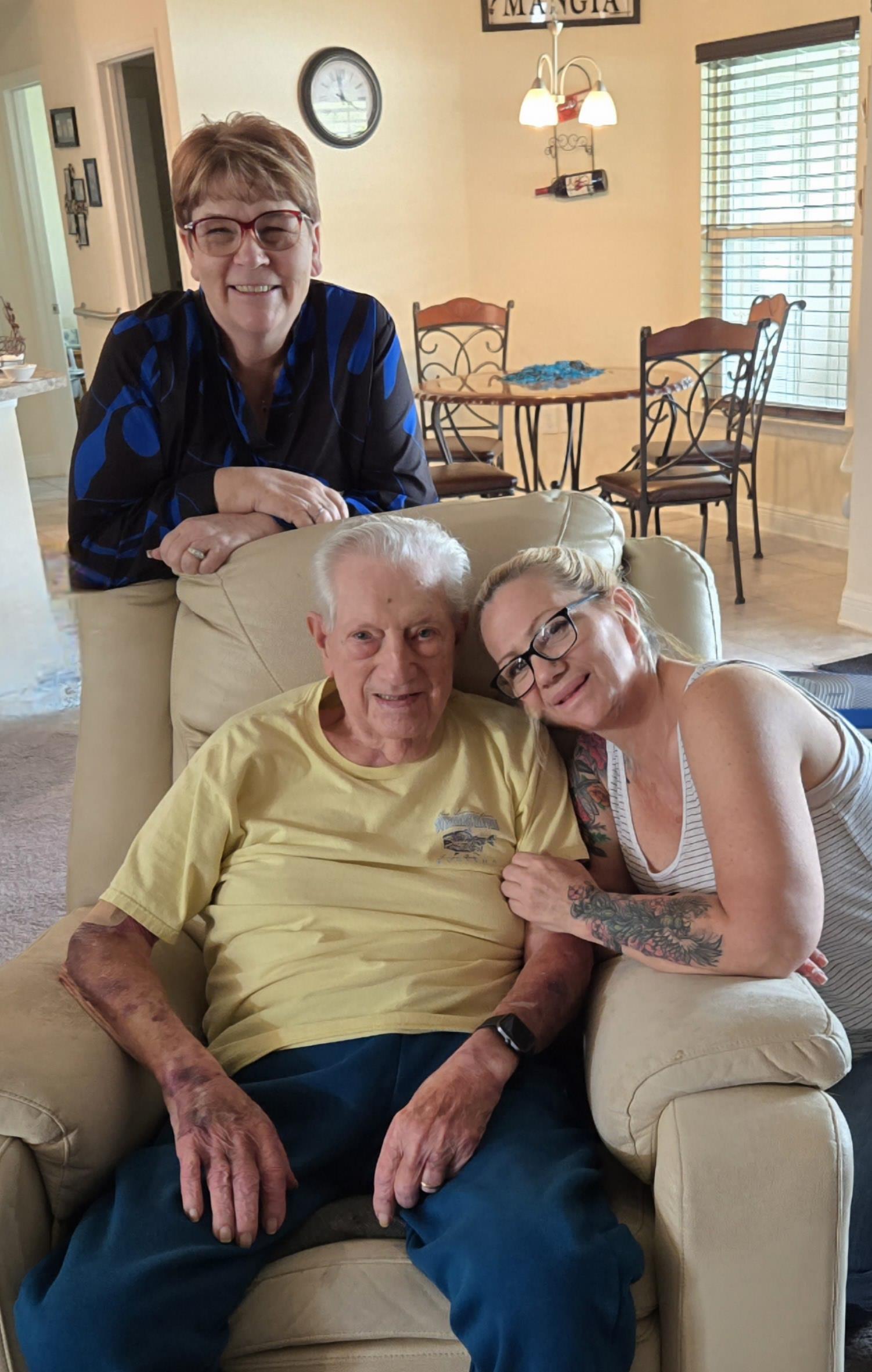 Three family members share a tender moment in a comfortable living room, radiating warmth and love.