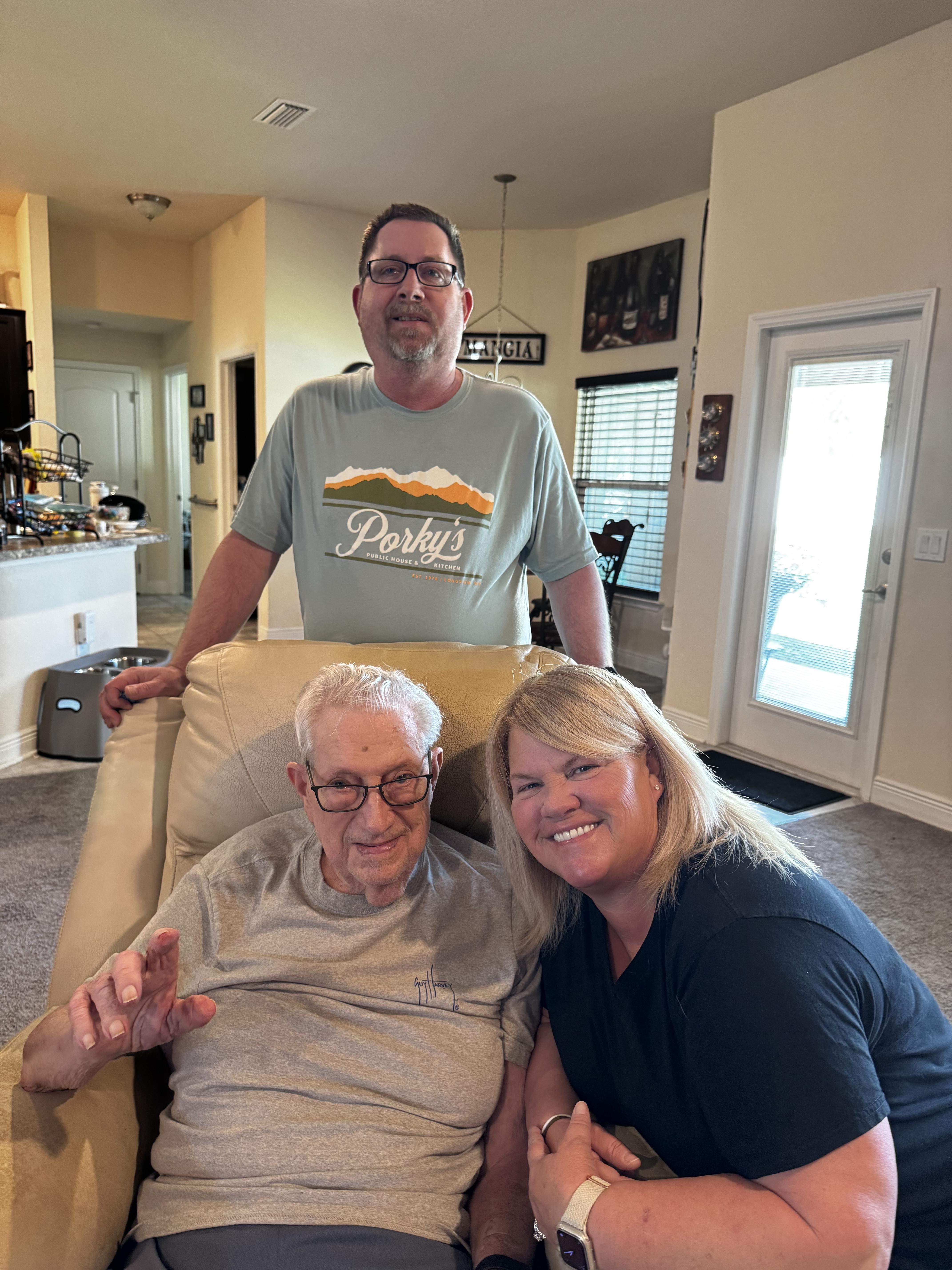Three relatives share a joyful moment in a warm, inviting living room filled with love.