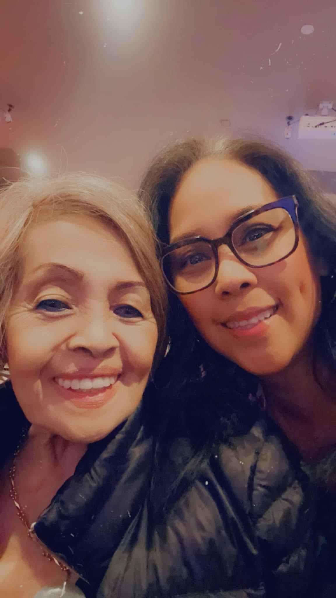 Two women are sharing a warm smile, celebrating a happy occasion during the night.