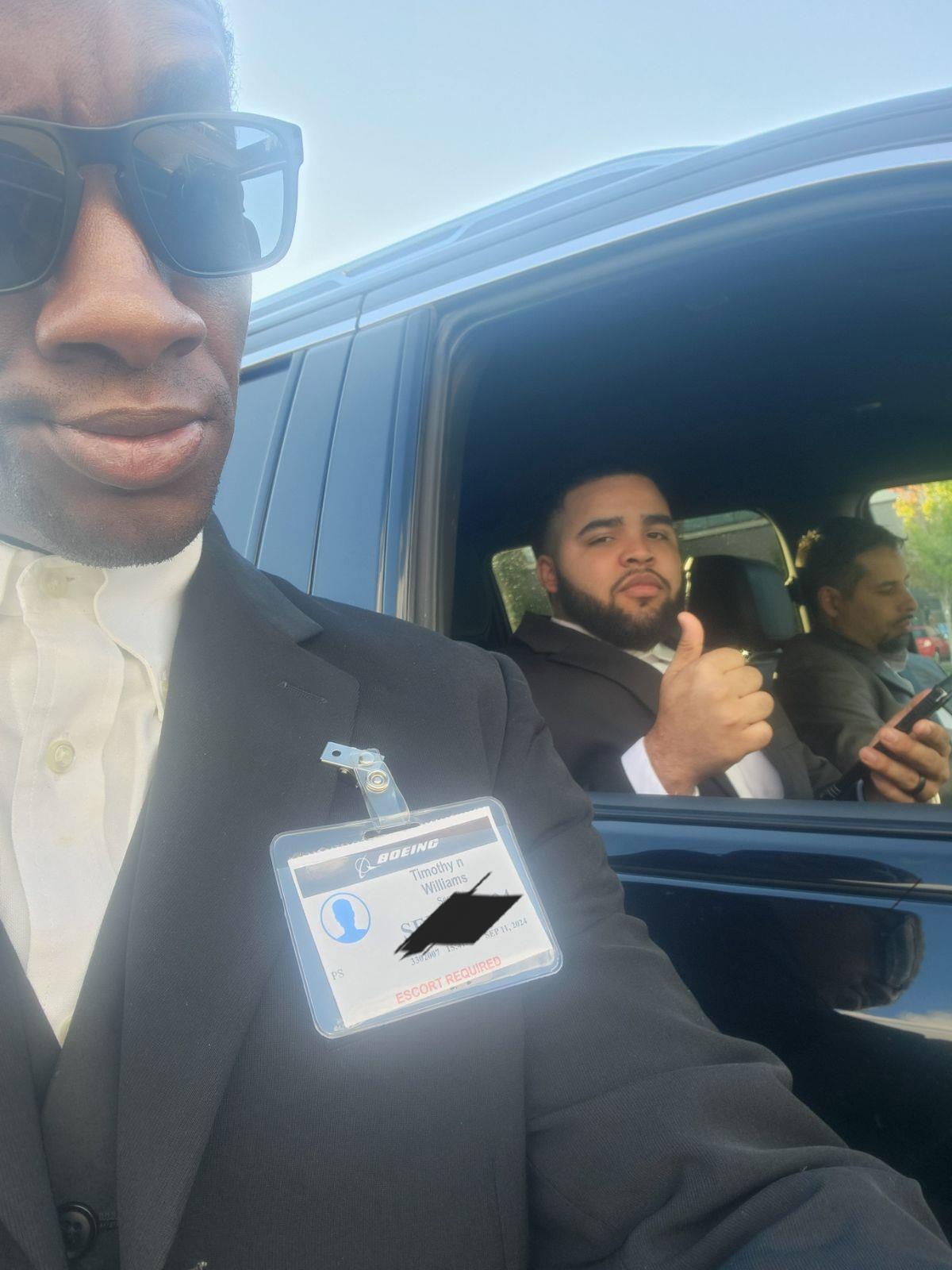 Two men are shown together, one is taking a selfie and the other is giving a thumbs up from the car.