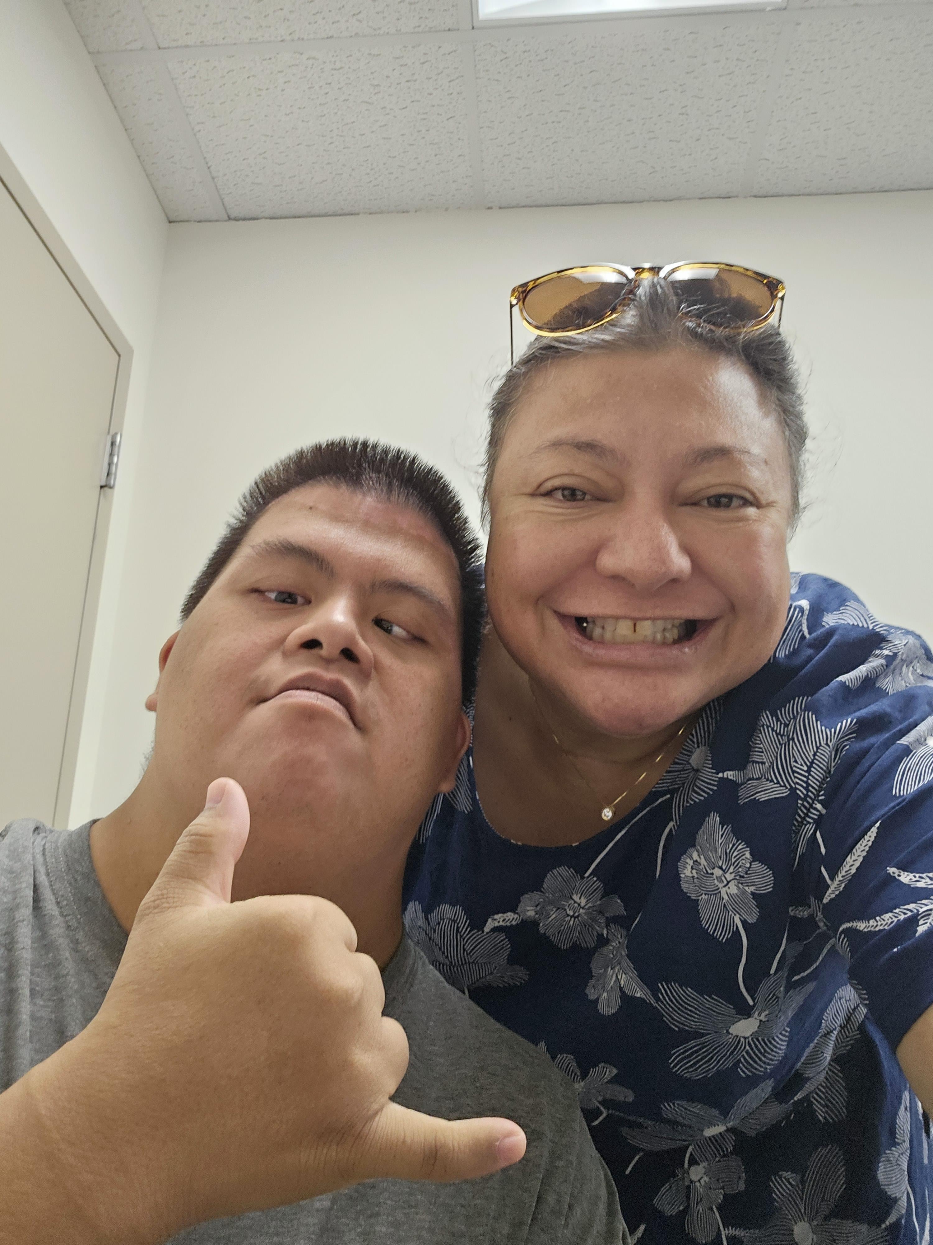 Two family members exhibit joy and connection while sitting together in a well-lit room.