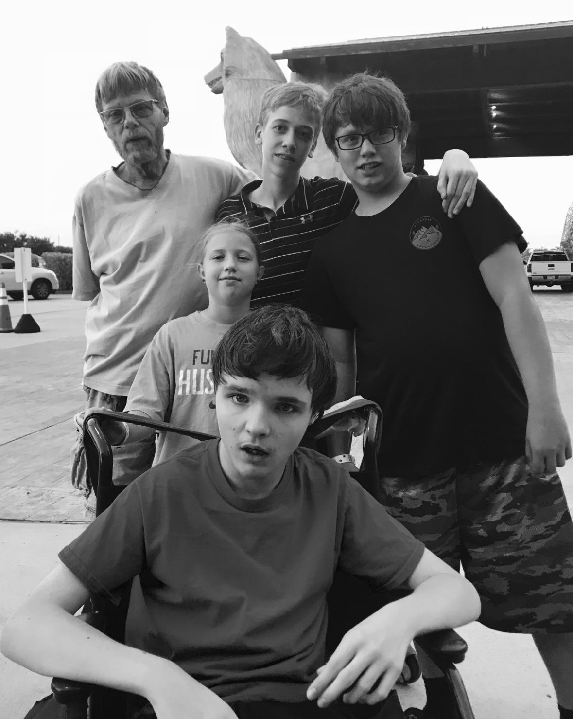 A group gathers outside a gas station, enjoying a moment together during summer.