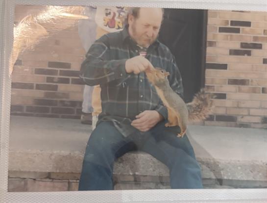 A man sitting on a step holding a squirrel