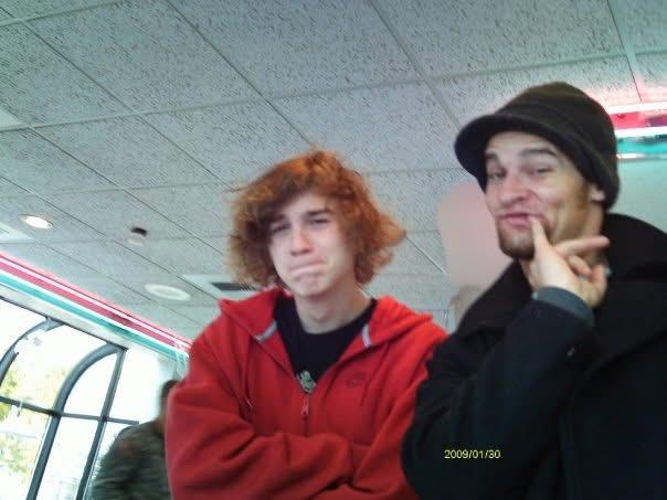 Two friends enjoy a relaxed moment indoors, showcasing their unique styles and expressions.