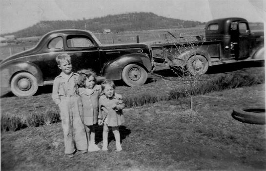 A group of children standing in front of a truck